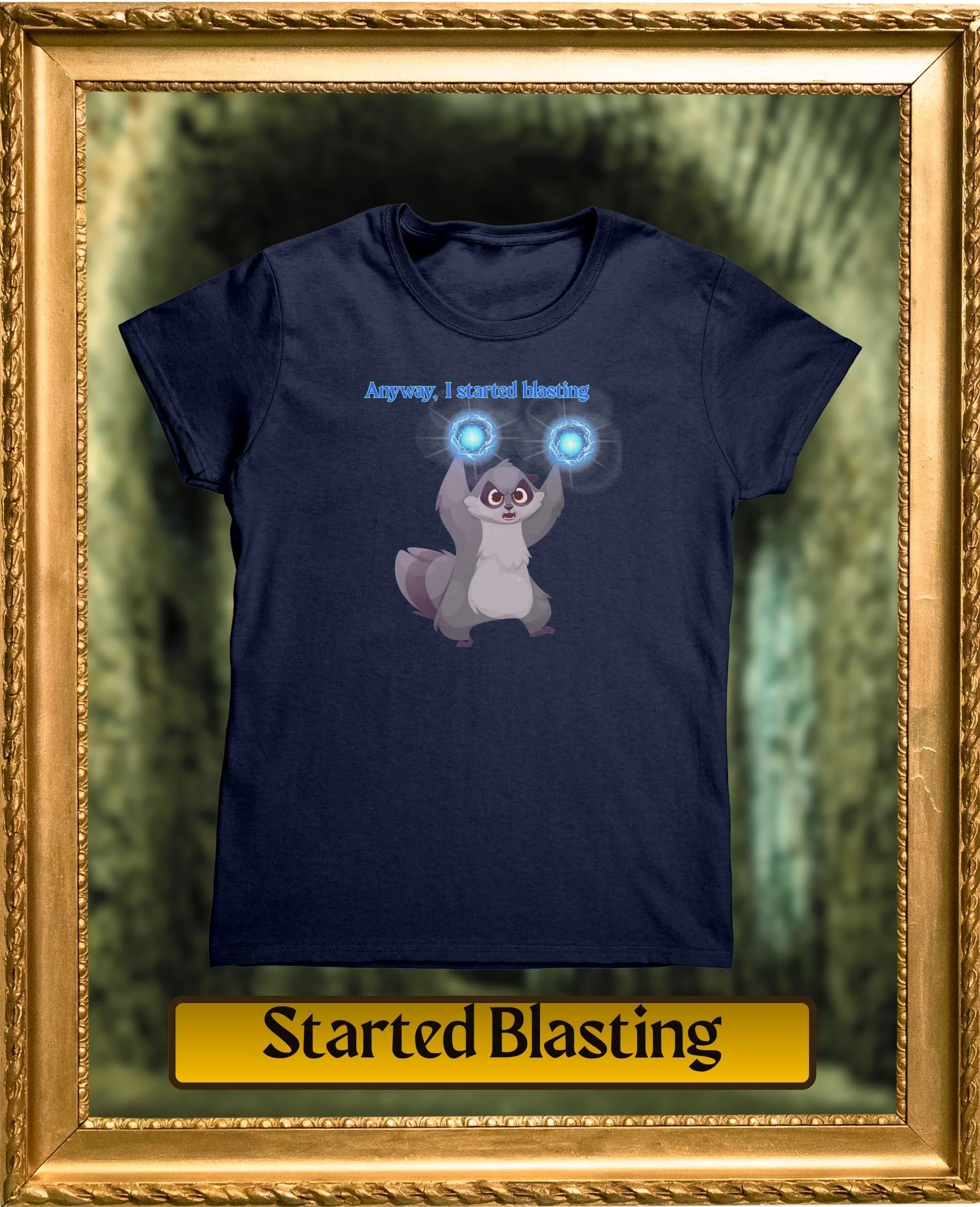 A navy blue T-shirt with a cartoon raccoon holding two blue energy balls and the text "Anyway, I started blasting" above the raccoon, framed by a decorative gold frame with a "Started Blasting" sign at the bottom, set against a blurred green outdoor background.