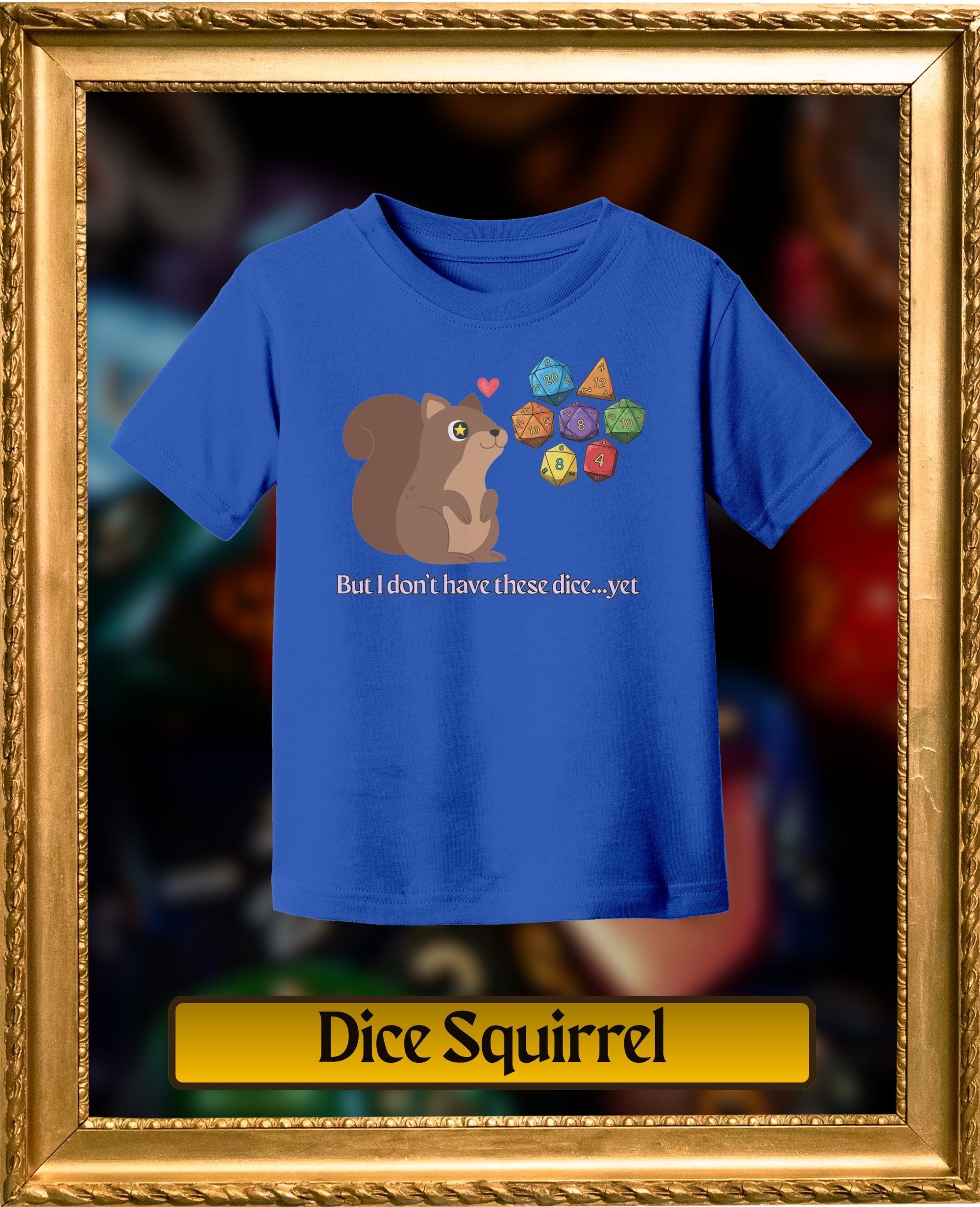 Blue T-shirt with a cartoon squirrel surrounded by colorful polyhedral dice and the text "But I don't have these dice...yet"