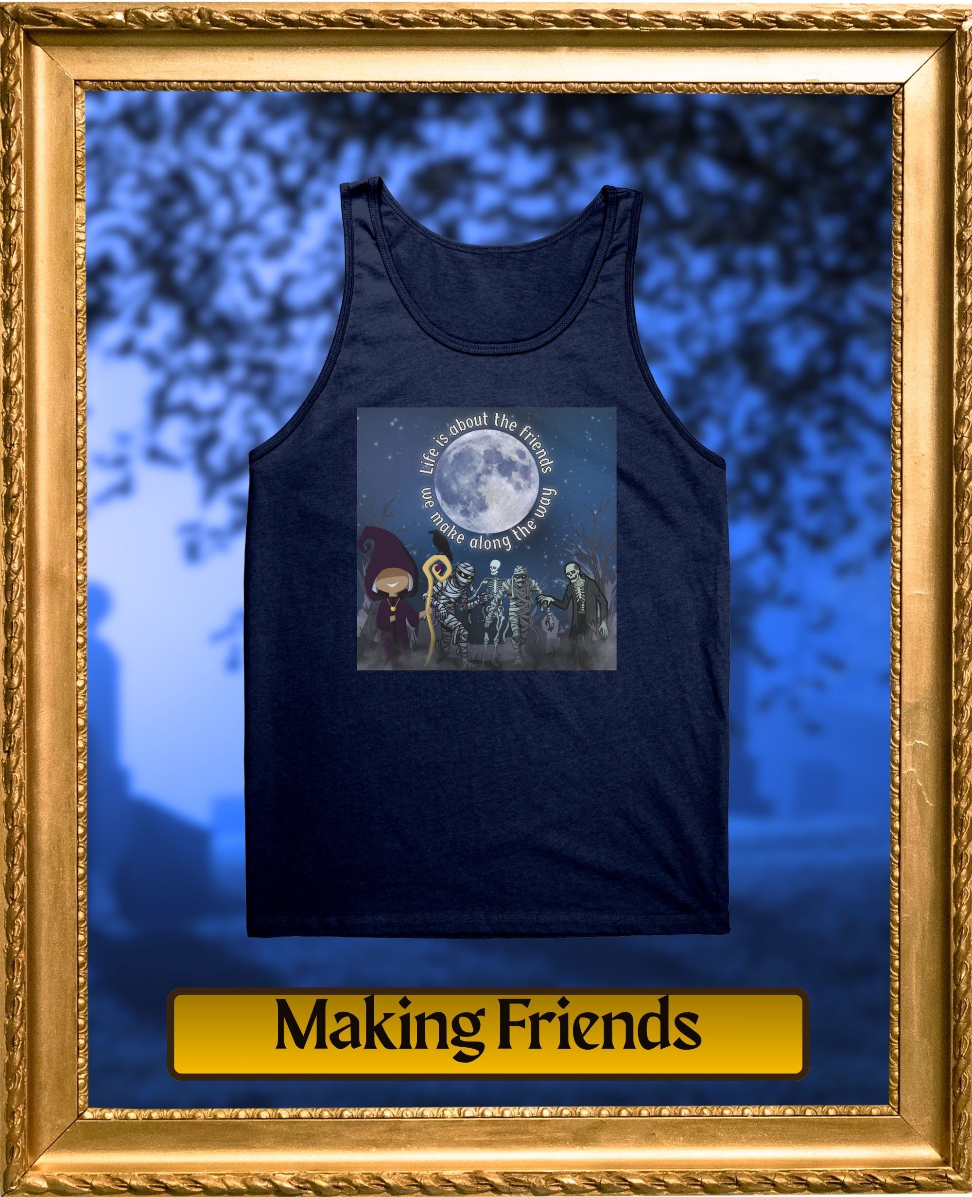 A dark blue tank top with a cartoon image of a night scene featuring a full moon, a girl in a purple hood, and a group of mummies with the text 'Life is about the friends we make along the way' above the moon. The tank top is framed by a gold ornate picture frame with a yellow sign below it that reads 'Making Friends'.