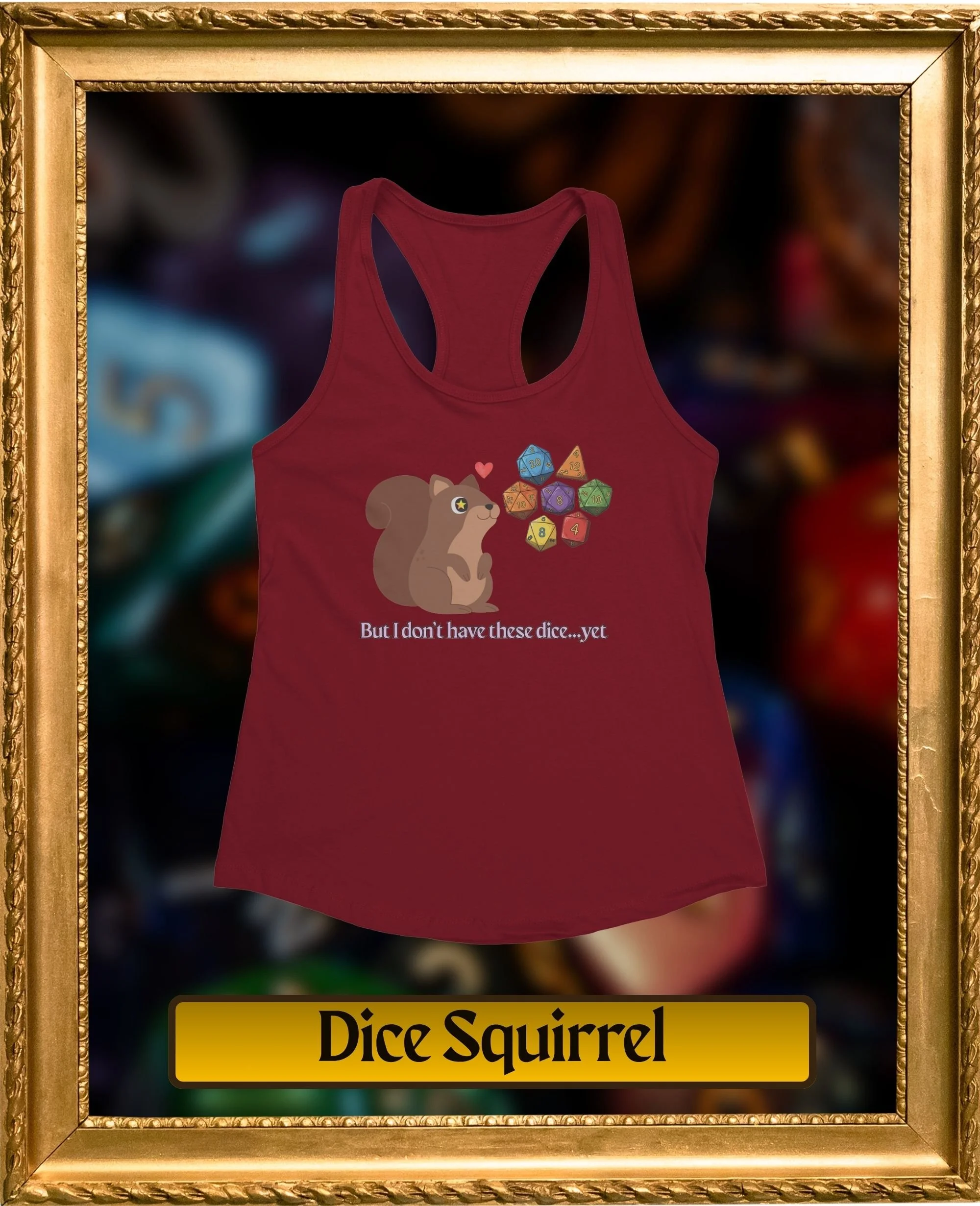A red tank top with a graphic of a squirrel surrounded by colorful dice and the text 'But I don't have these dice...yet' underneath. The photo is framed with a gold ornate border.