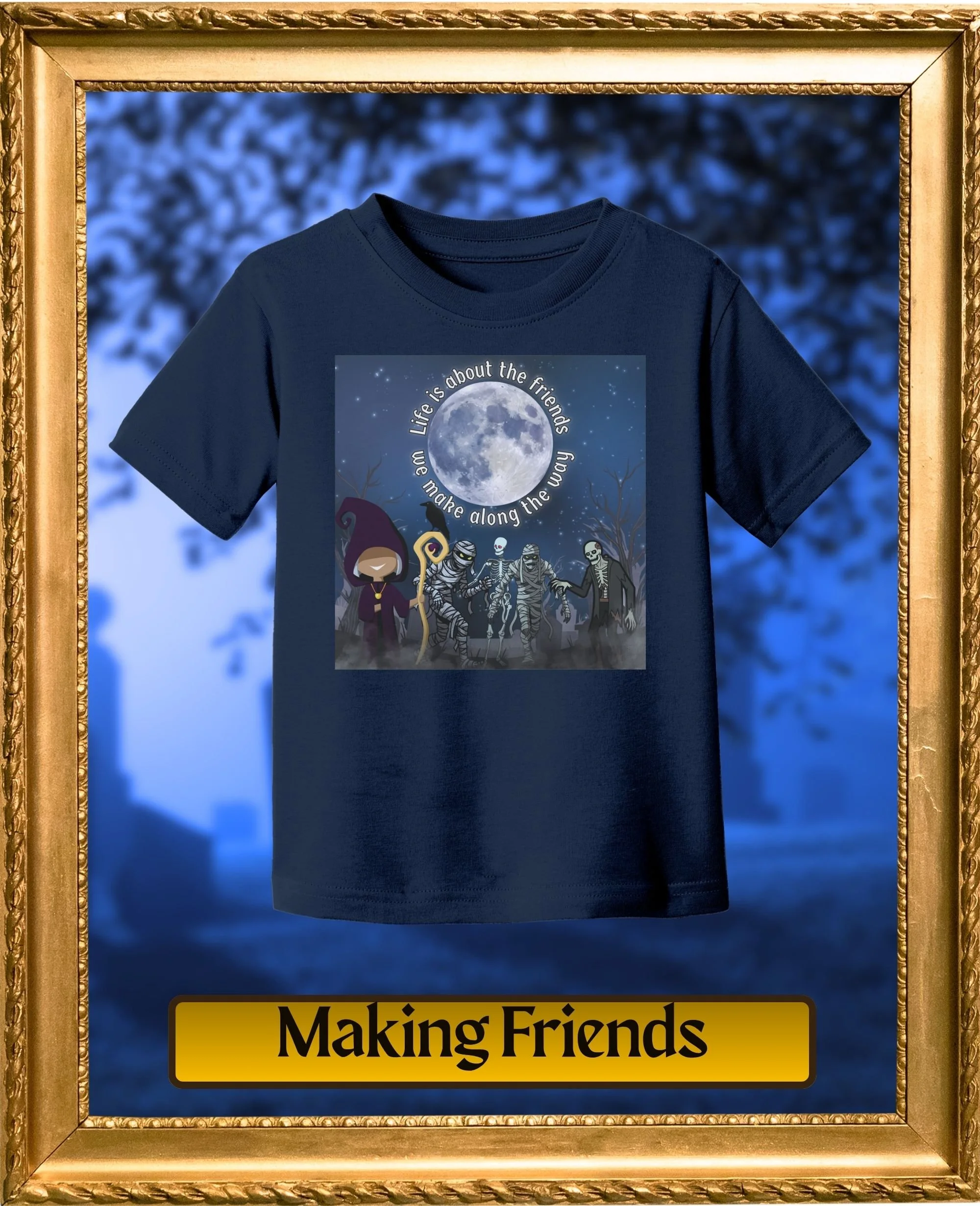 A dark blue T-shirt with a graphic design featuring a full moon, cartoon characters, and the text 'Life is about the friends we make along the way' inside a gold-colored frame. The bottom part of the image shows a yellow sign with black text reading 'Making Friends'.