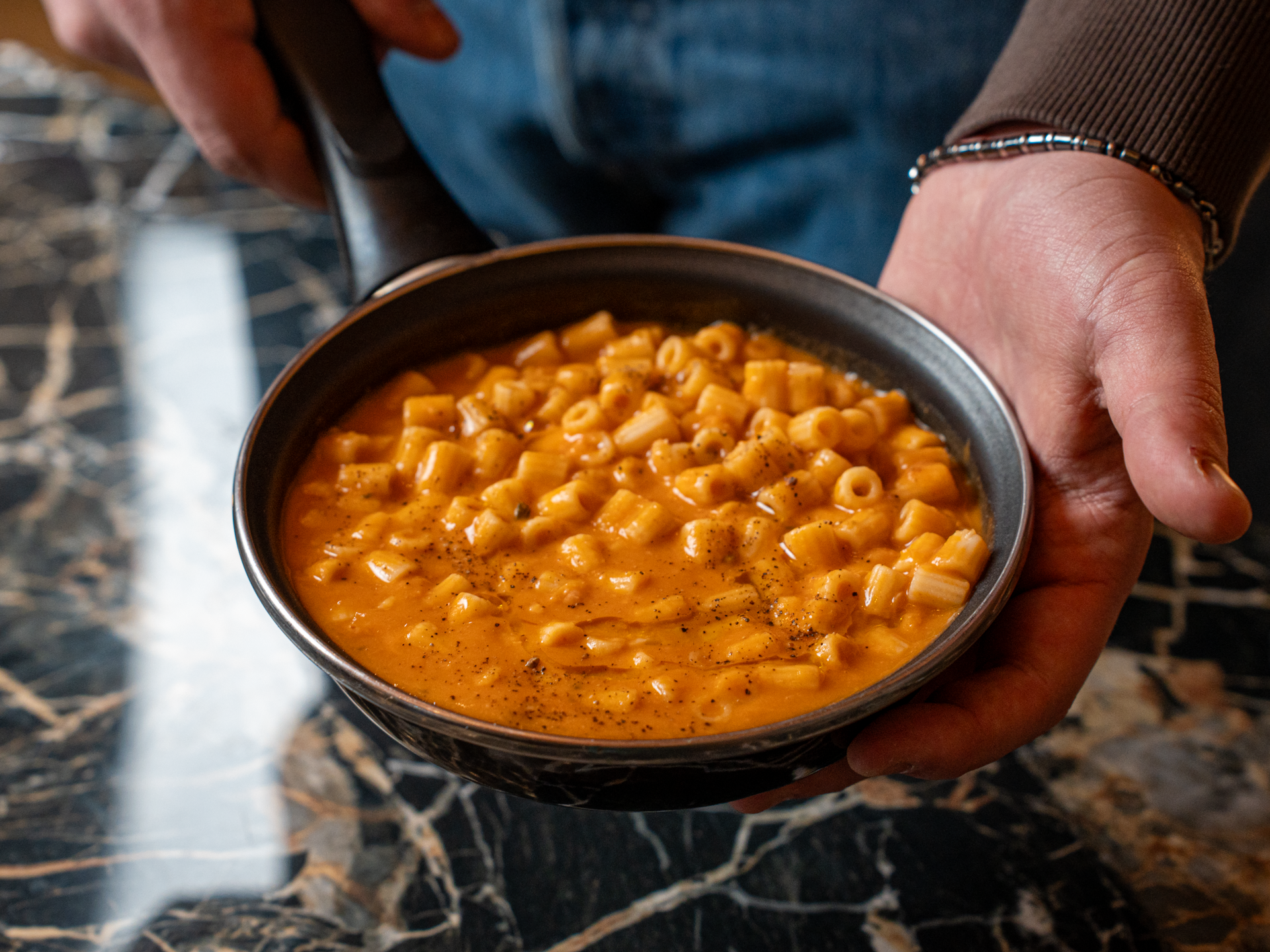 Una mano tiene una ciotola con pasta di fagioli, piatto tipico.
