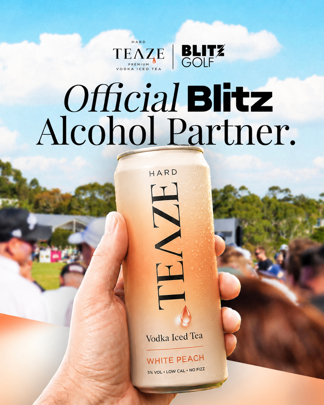 A hand holding a can of Teaze vodka iced tea with a festival with people, trees, tents, and a stage in the background.