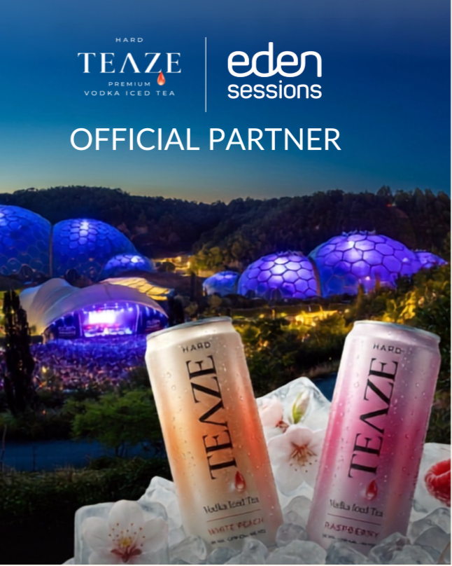 Night view of the Eden Sessions music festival with illuminated domes, featuring two cans of TEAZE Hard Tea with flavors Water Peach and Raspberry in the foreground surrounded by ice and flowers.