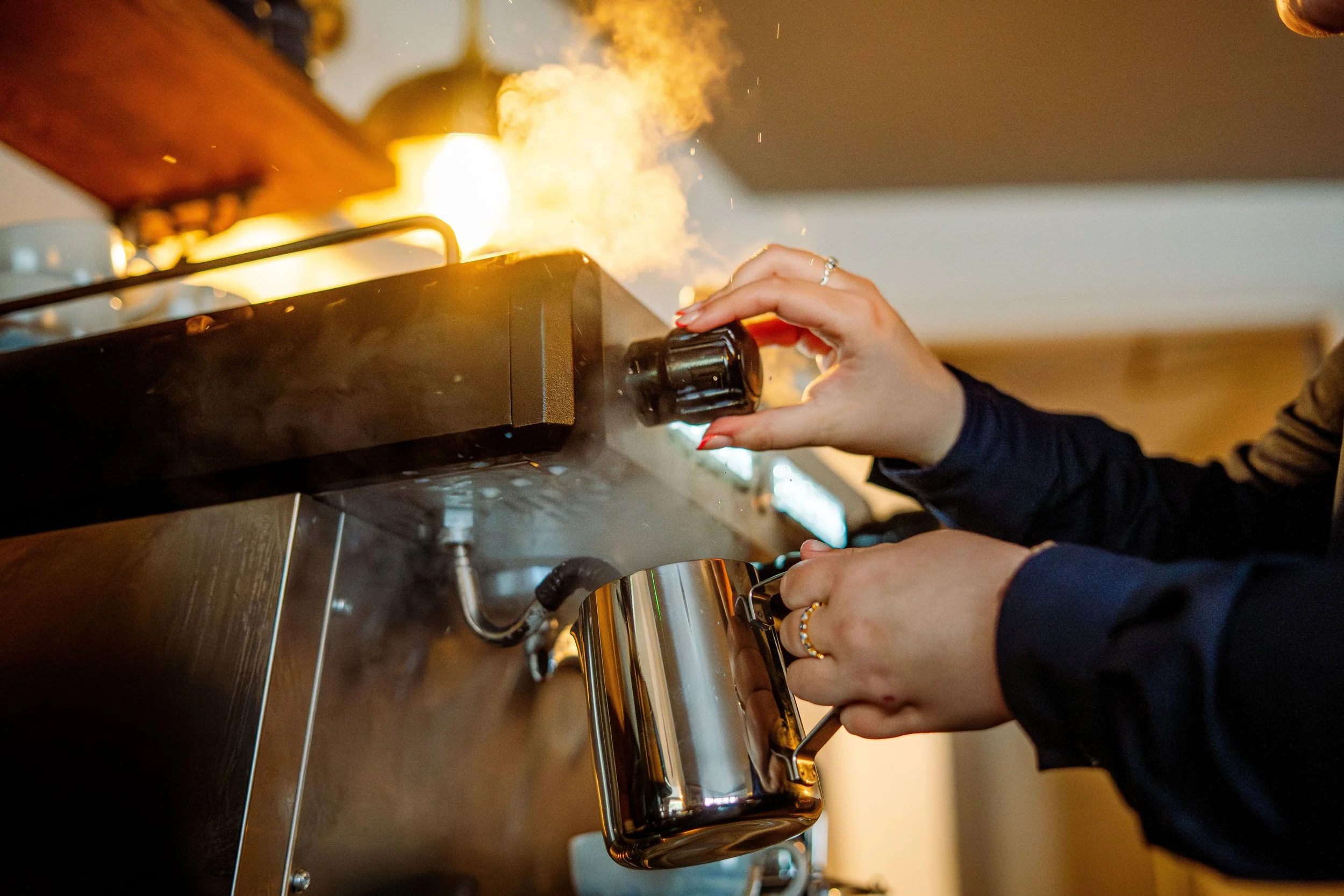 Person using a blowtorch to caramelize the sugar on a dessert in a kitchen.