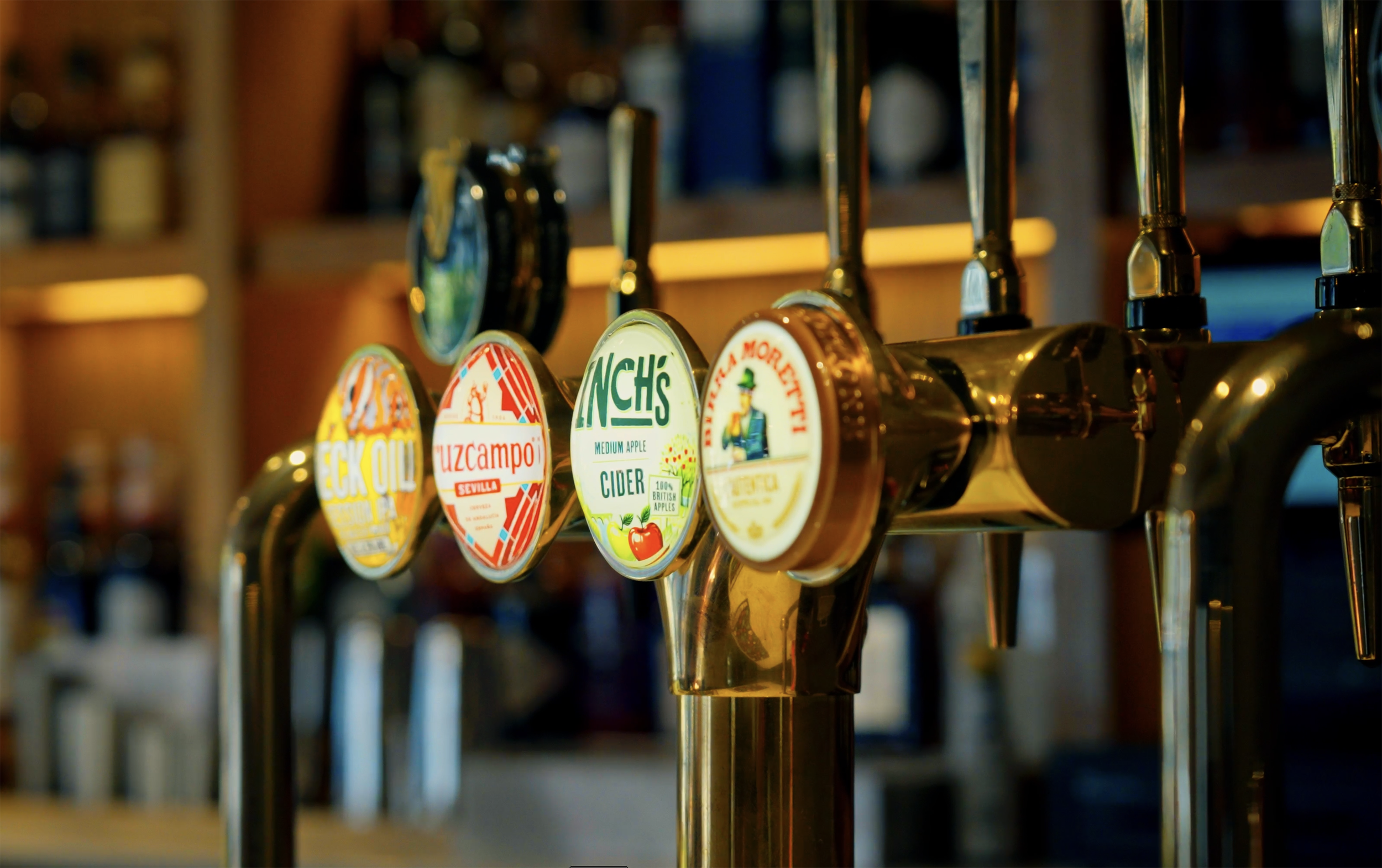 Beer taps with colorful labels in a bar.