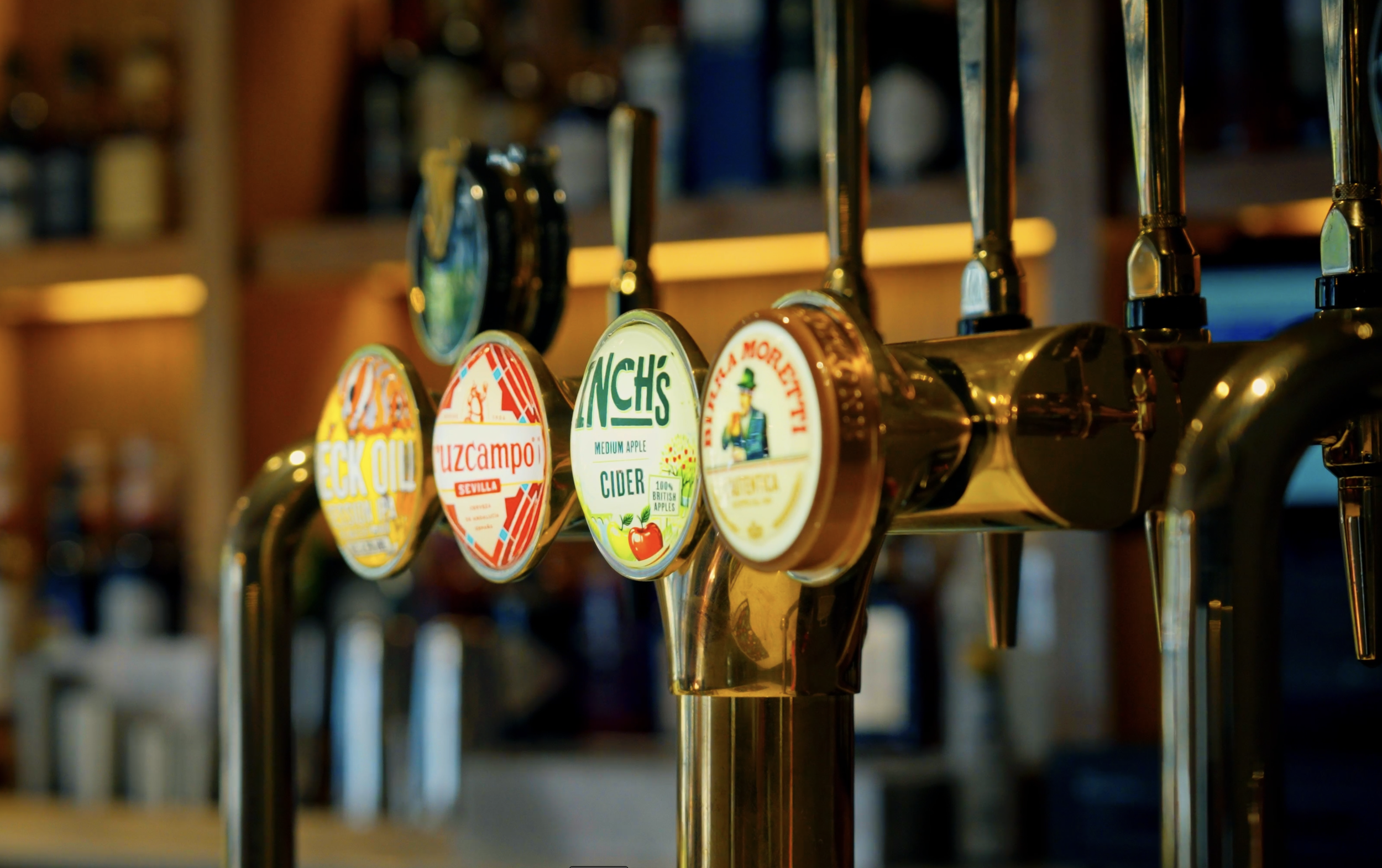 Beer taps with various labels in a bar.