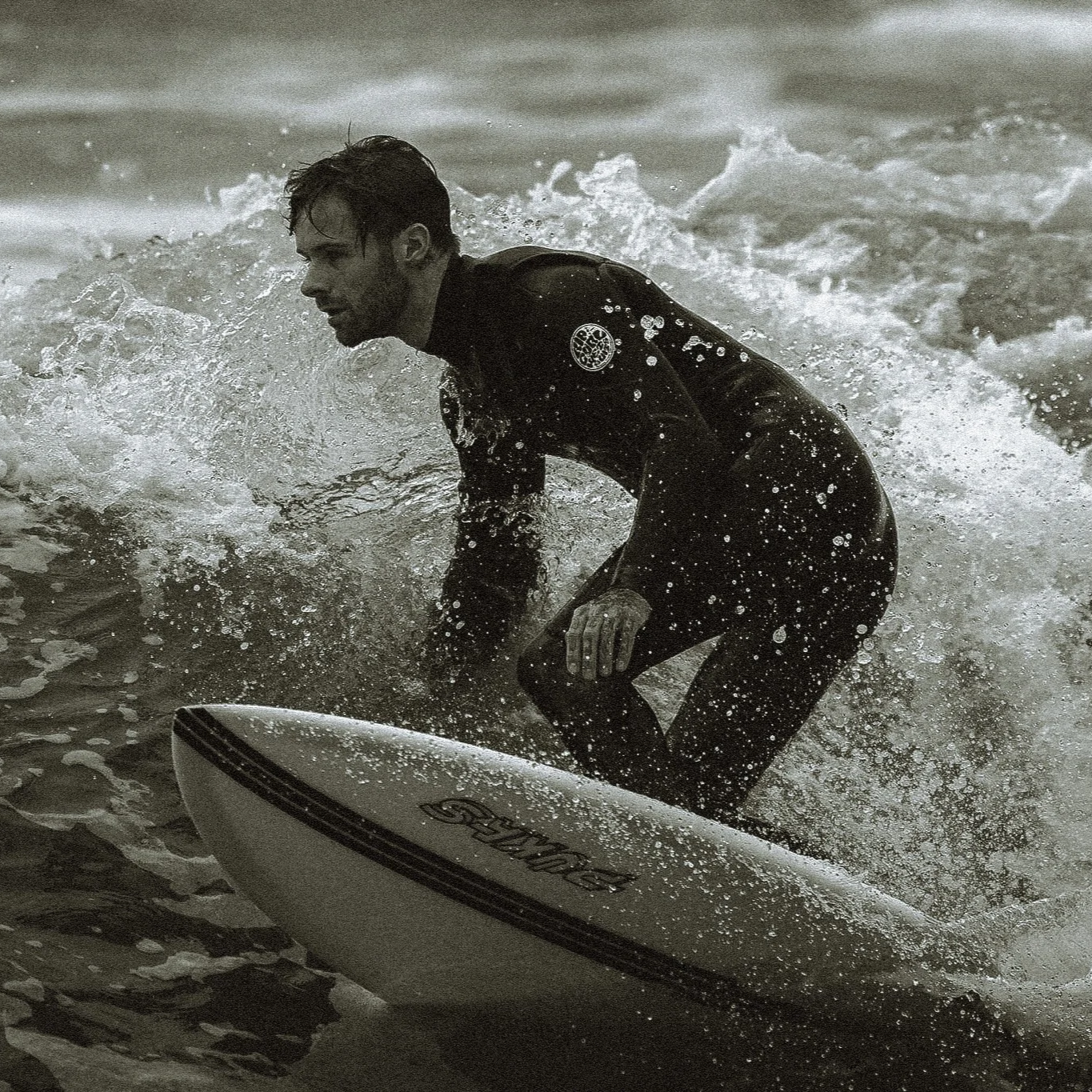 A man in a wetsuit is riding a surfboard on the waves in the ocean.