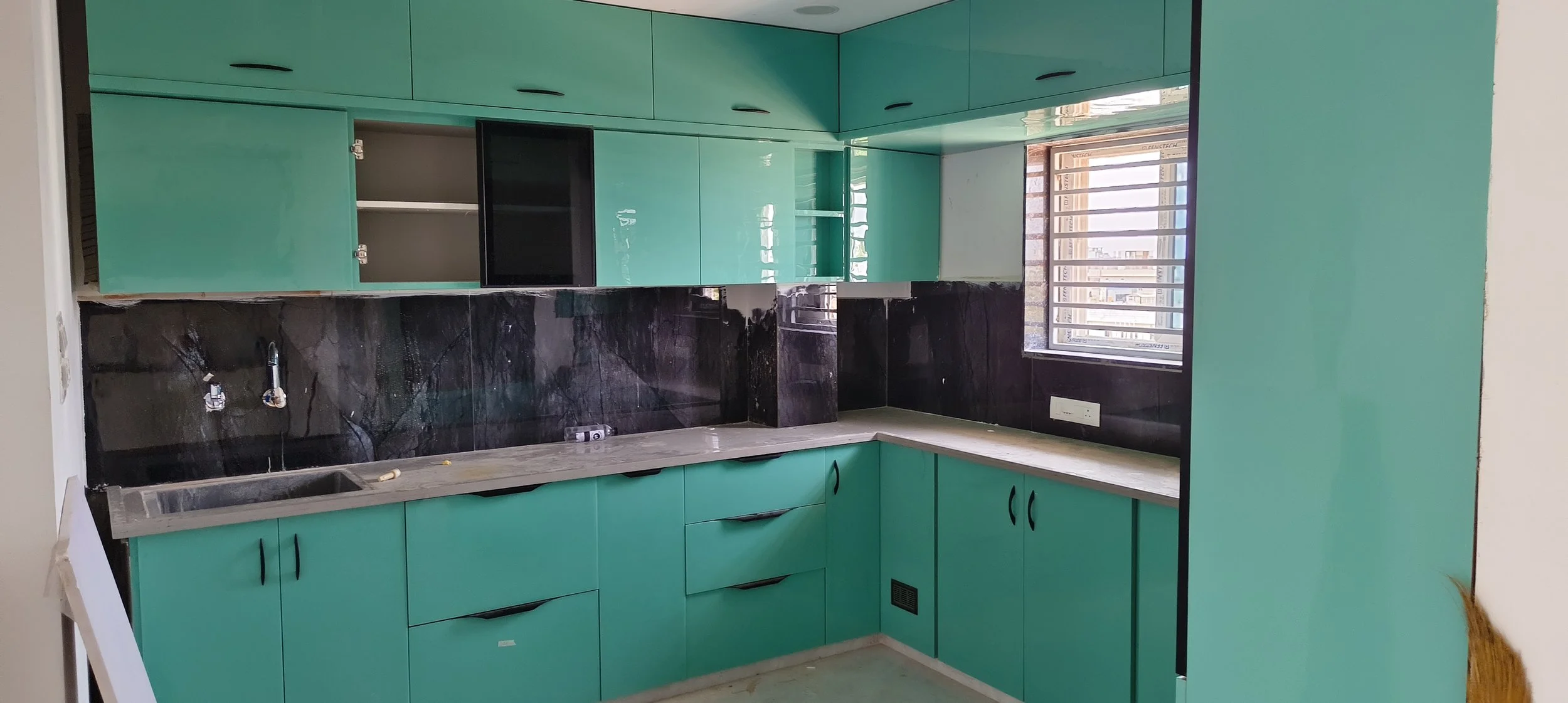 L-shaped modular kitchen with matte finish and smart storage in Sri Nagar Colony Khammam.