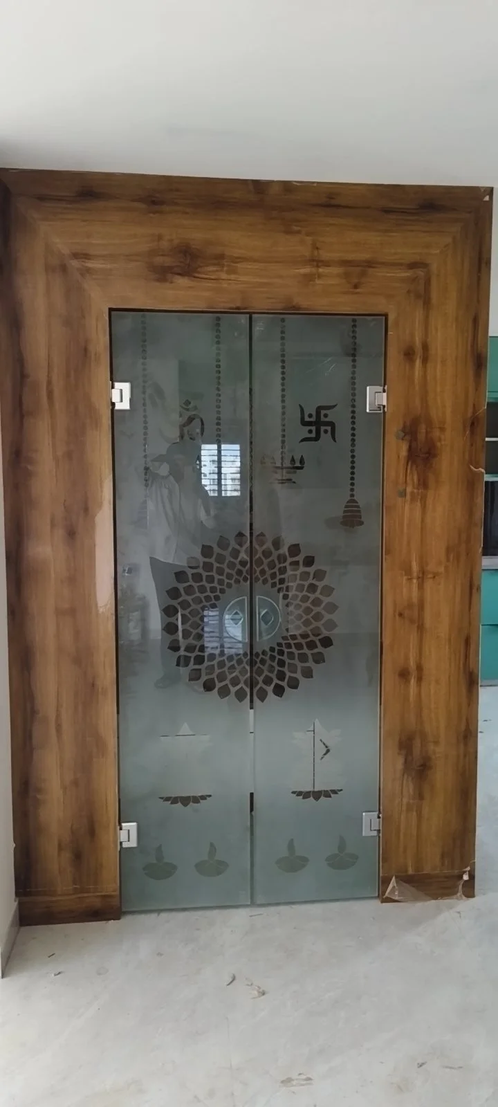 Traditional Pooja room door with CNC cutting and brass fittings in Sri Nagar Colony Khammam.