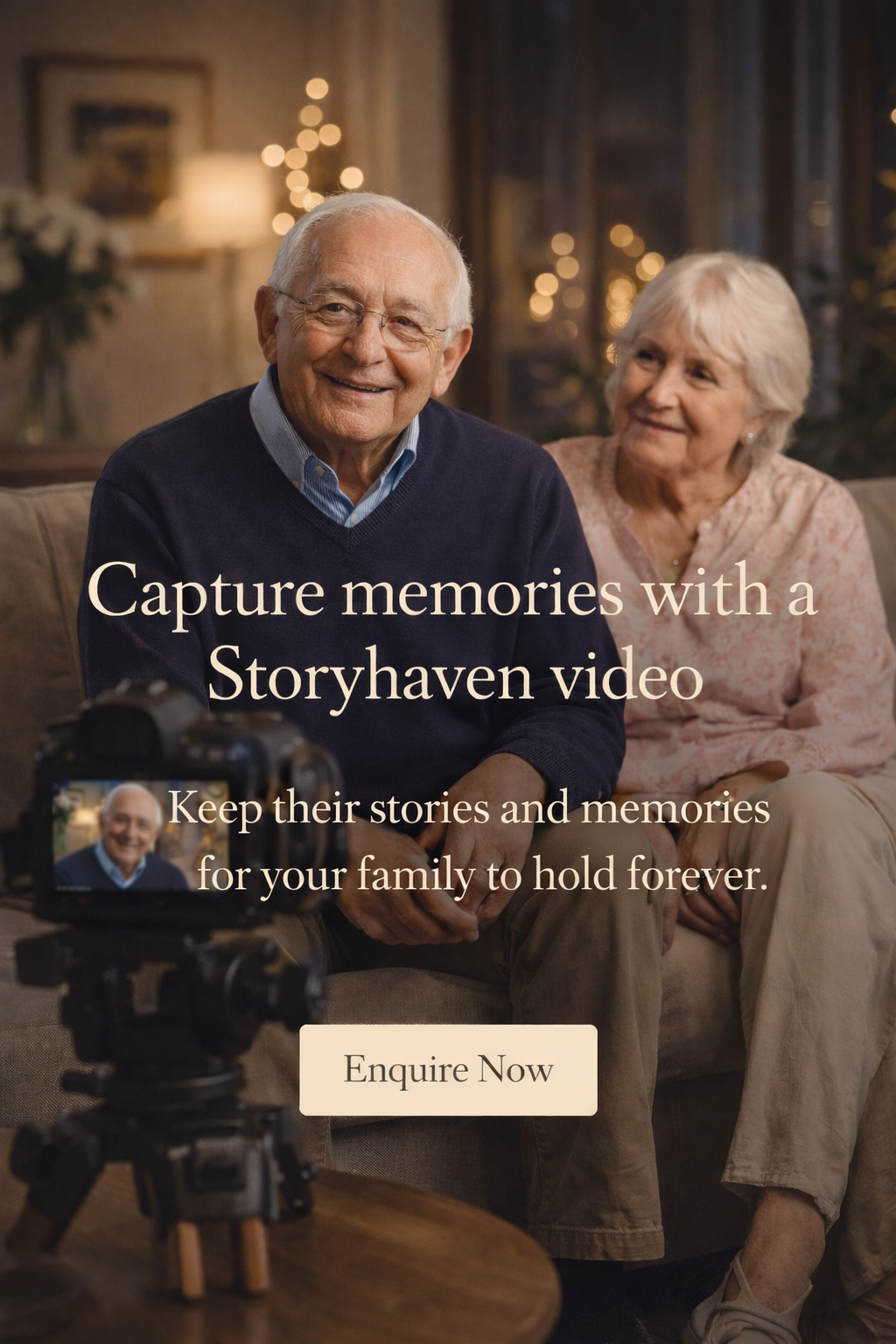 An elderly man and woman sitting on a couch, smiling at a camera with a camera on a tripod in front of them. The background shows warm lighting and blurred Christmas decorations.