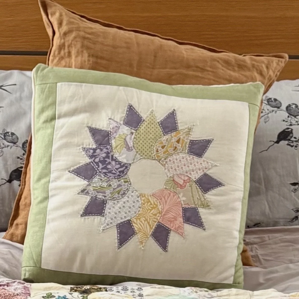 Handmade appliqué wreath cushion, an example of a Brighton Stitch memory cushion made from treasured fabrics