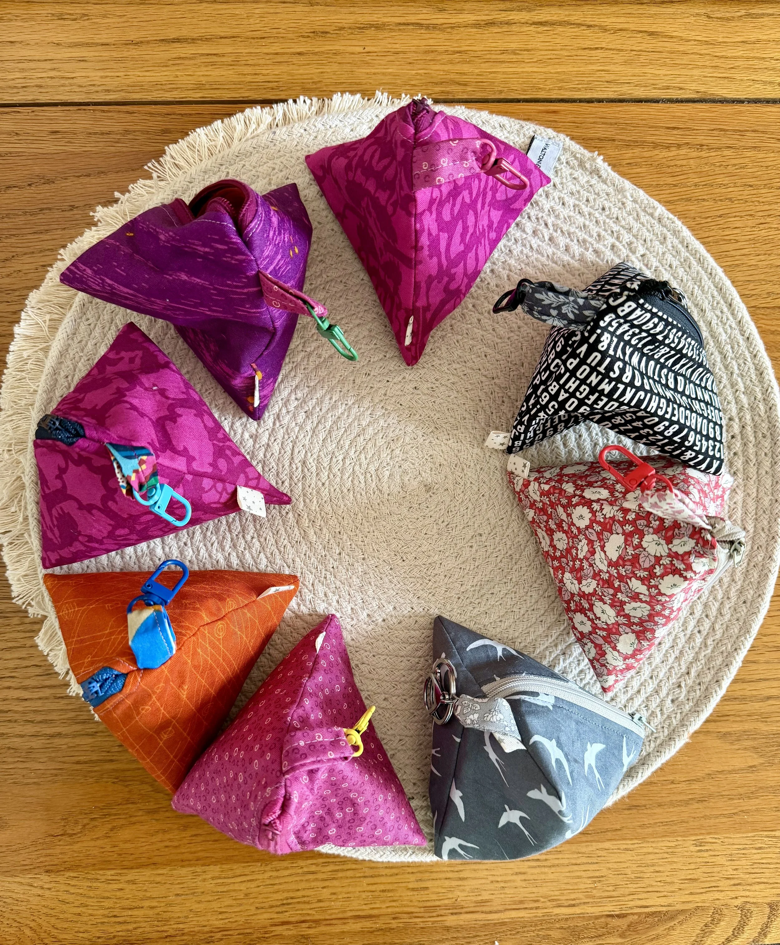 Aerial view of handmade Little Keeps triangle zip pouches in colourful fabrics.