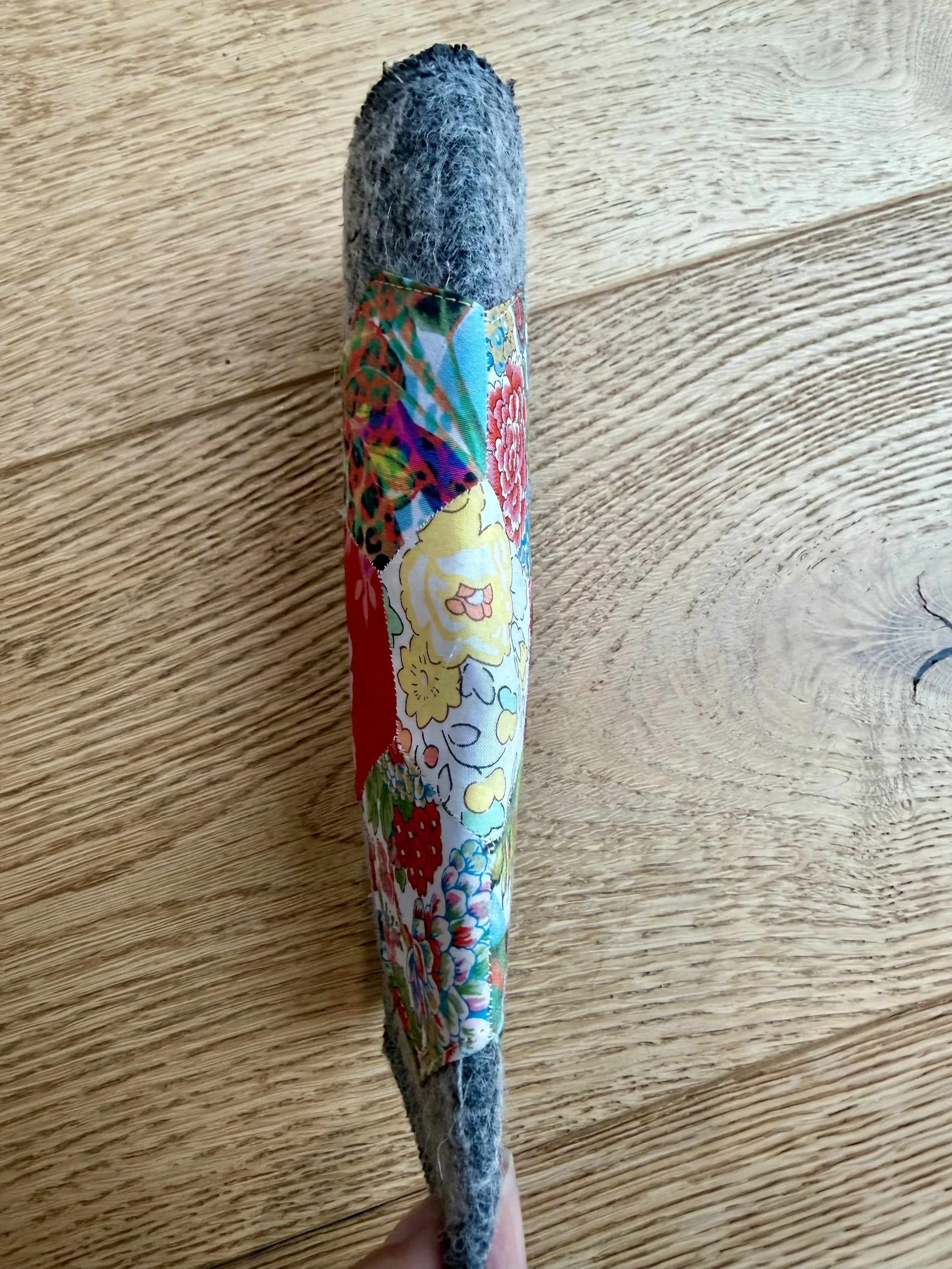 Side view of grey wool glasses case showing Liberty patchwork wrapping around the case