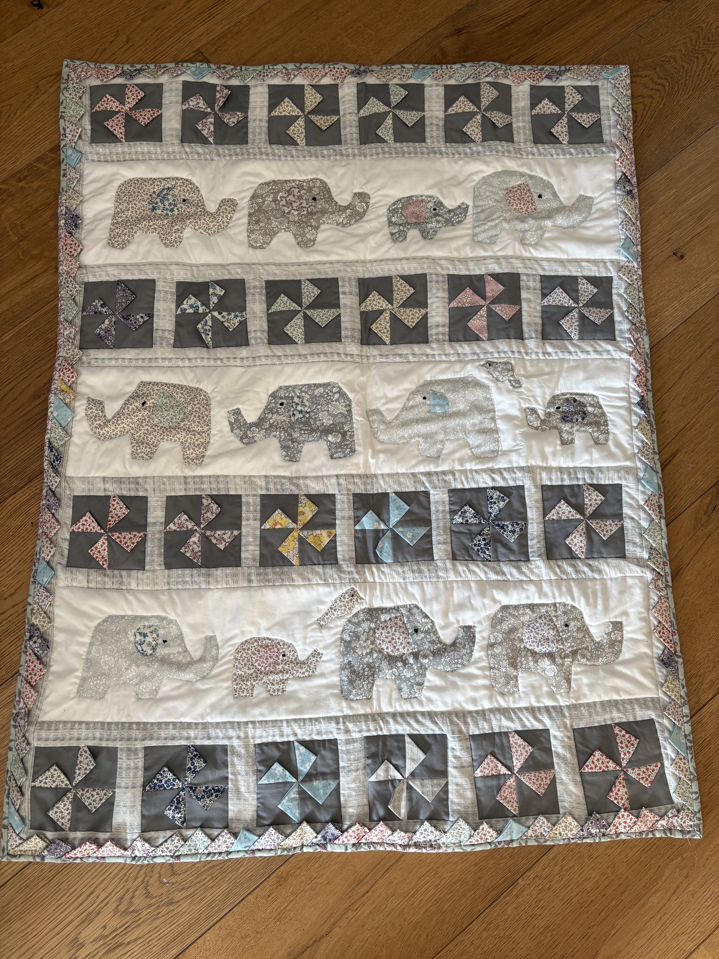 Handmade appliqué quilt, an example of a Brighton Stitch baby quilt made from cotton fabrics