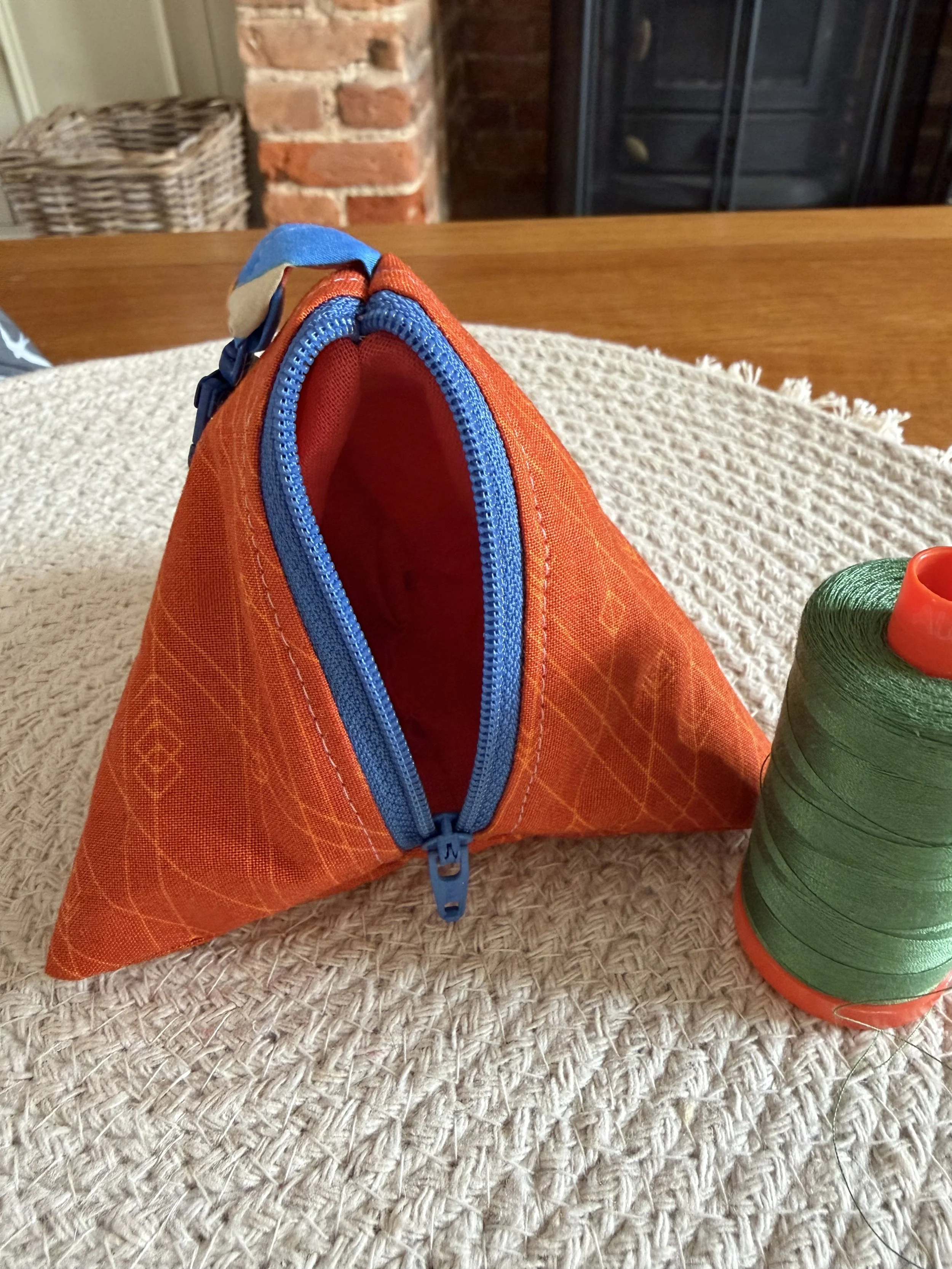 Open Little Keeps triangle zip pouch showing its contrasting orange fabric lining.