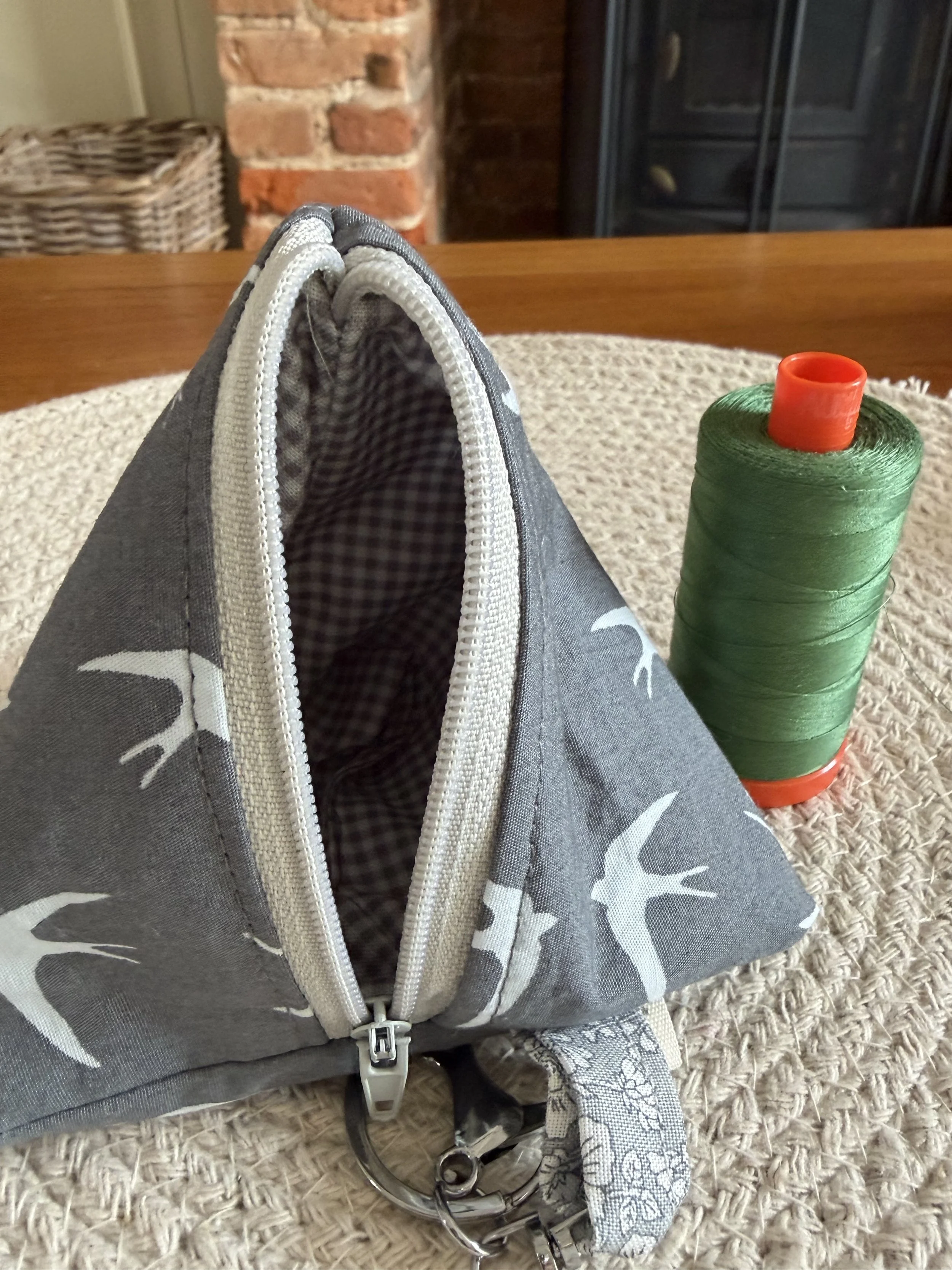 Open Little Keeps triangle zip pouch showing its contrasting grey gingham fabric lining.