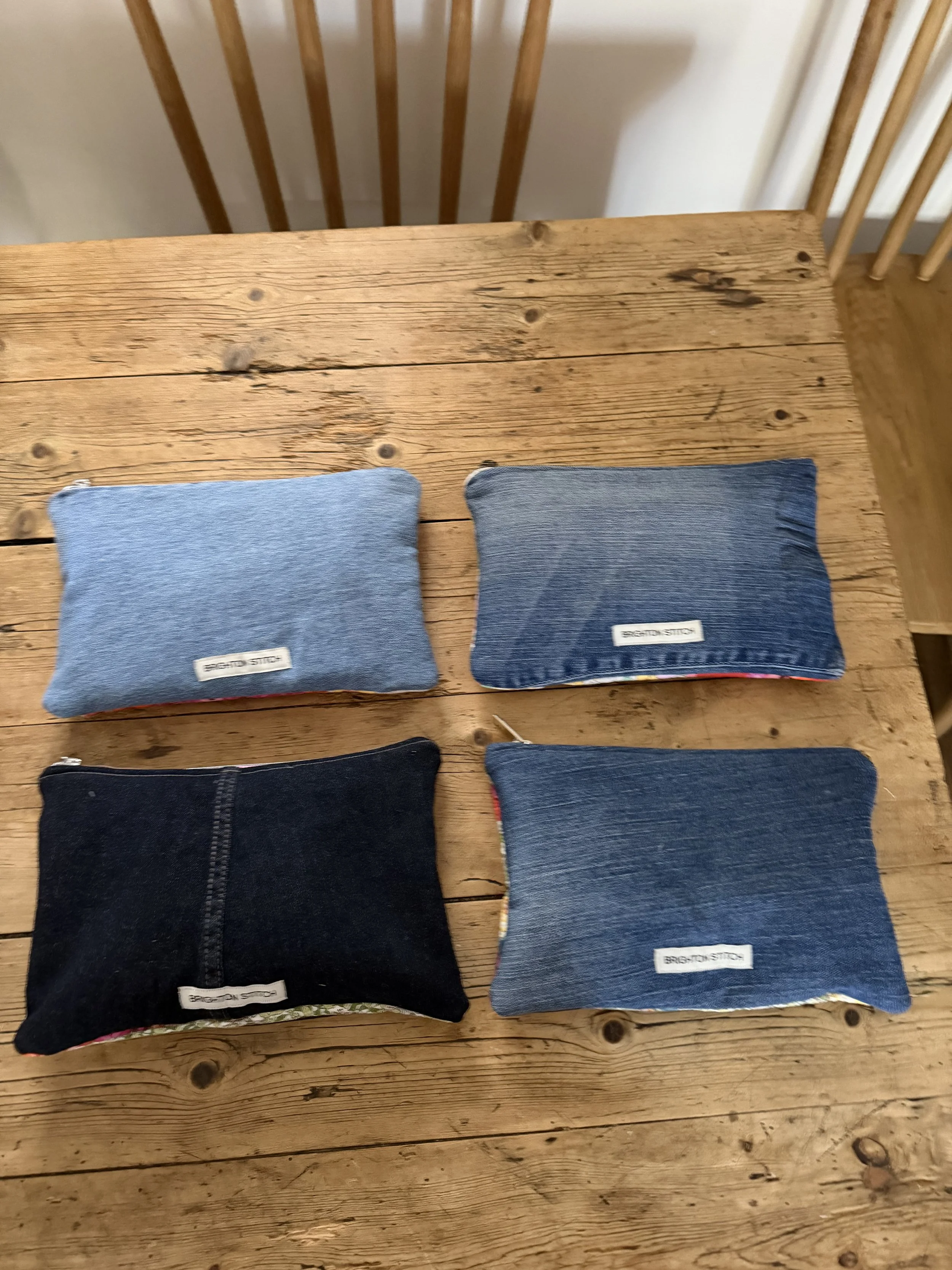 Four Tutti Fruitti pouches showing dark indigo and mid blue reclaimed denim backs