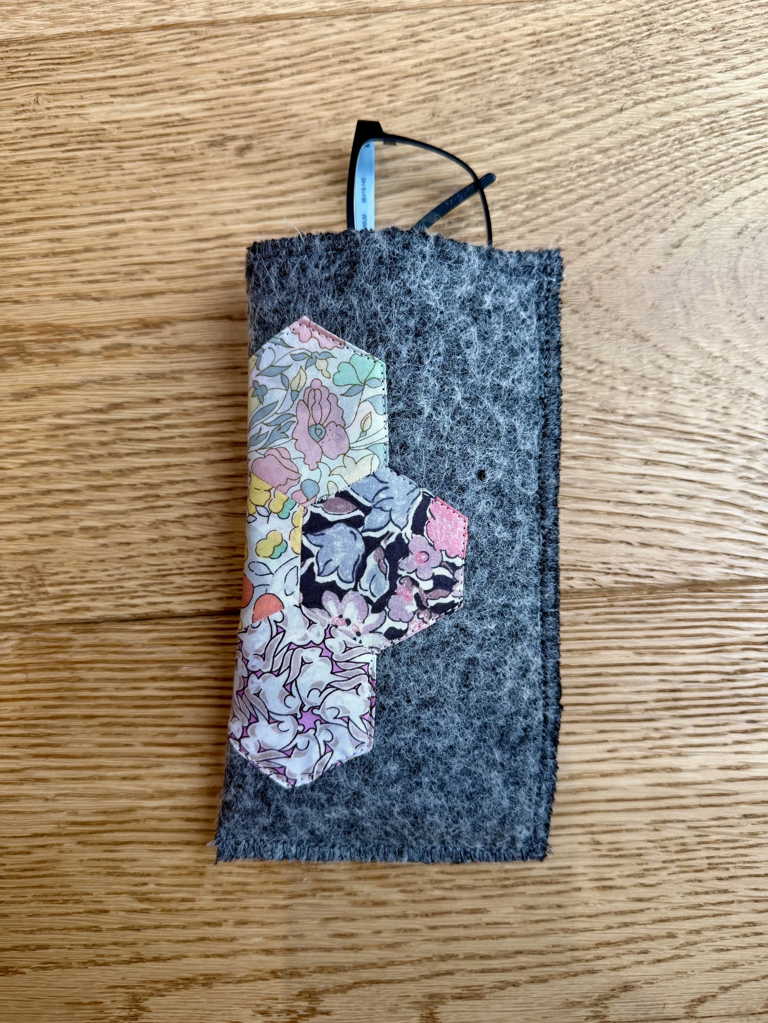 Grey wool Liberty Scrap Garden glasses case with pink floral patchwork and black glasses