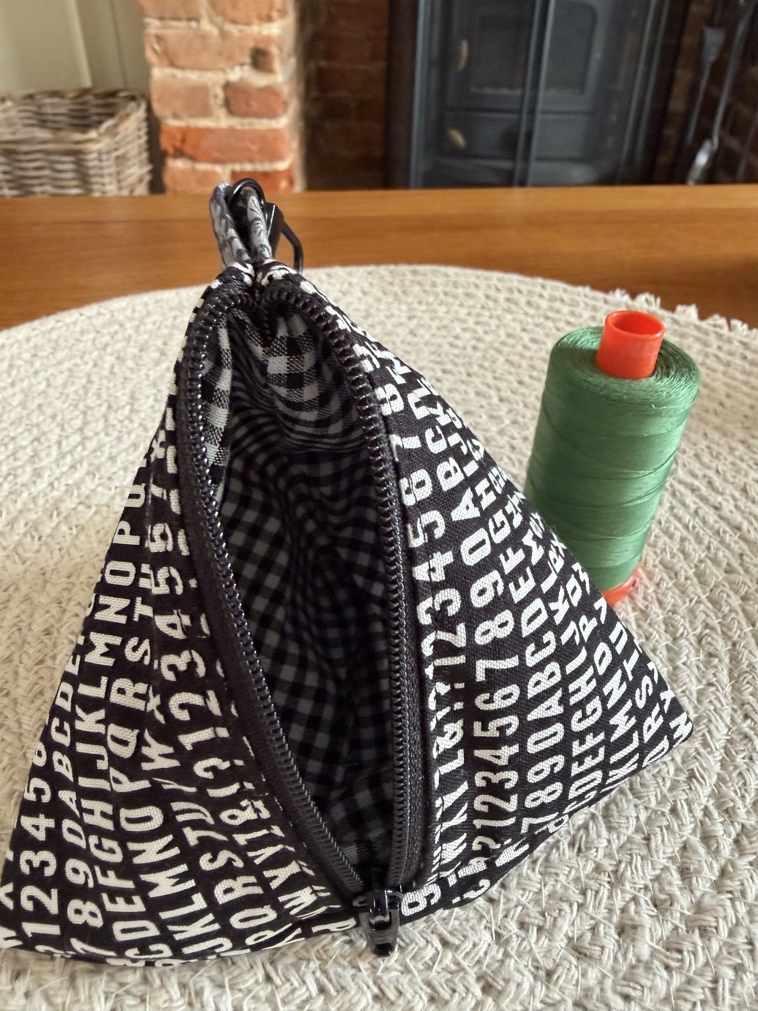 Open Little Keeps triangle zip pouch showing its contrasting black gingham fabric lining.