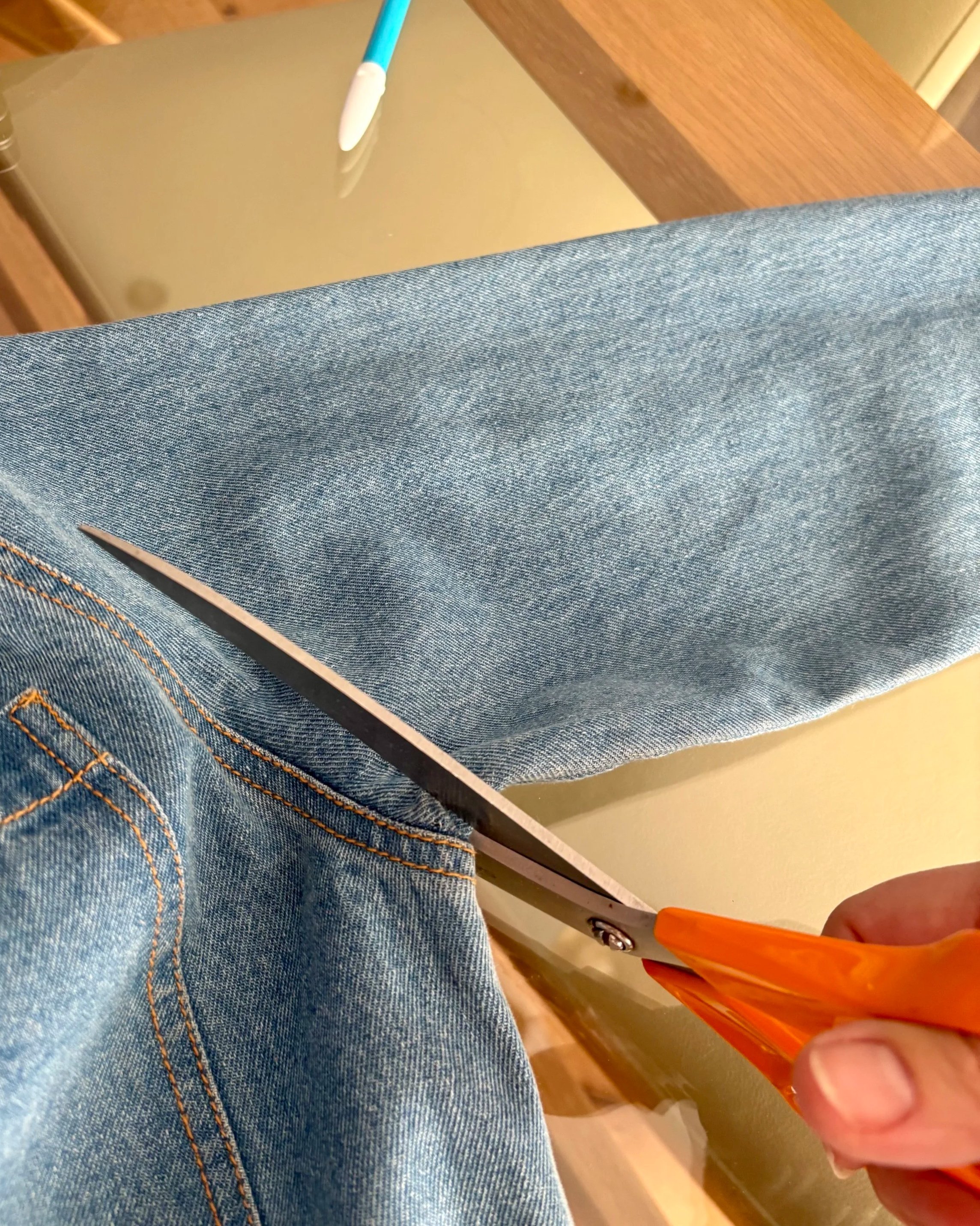 Lindsay cutting reclaimed denim fabric in the Brighton Stitch studio.