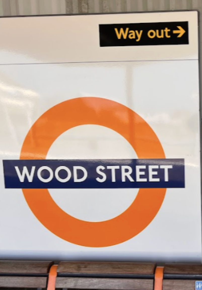 Sign with the London Underground symbol reading "Wood Street" and an arrow indicating the way out.