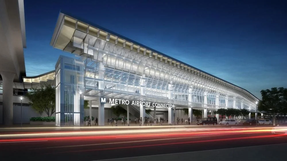 Nighttime exterior view of the Metro Airport Connector building with illuminated modern glass architecture and a sign reading "Metro Airport Connector."