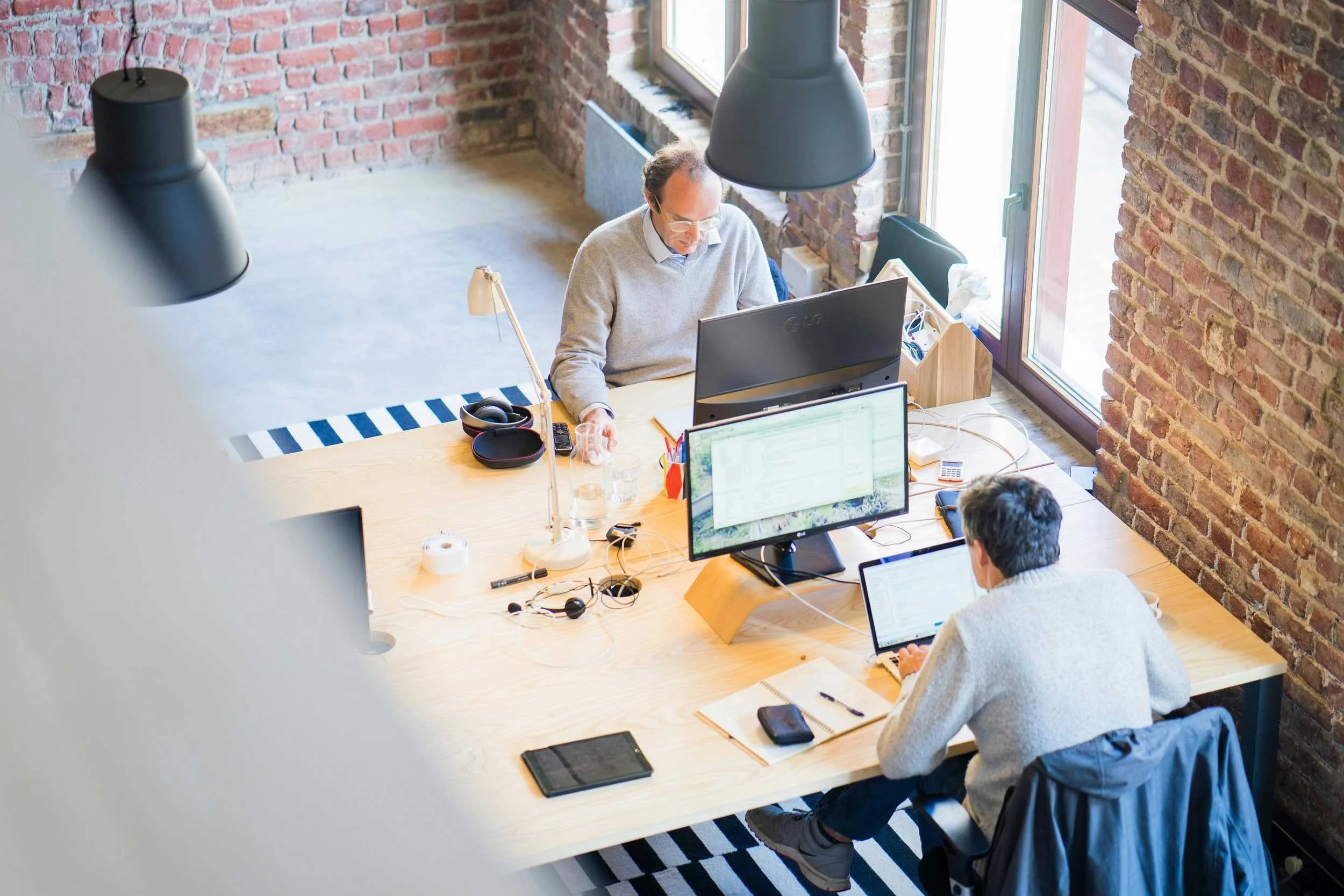 Employees working at computers in a modern office, representing services provided by a business insurance broker.