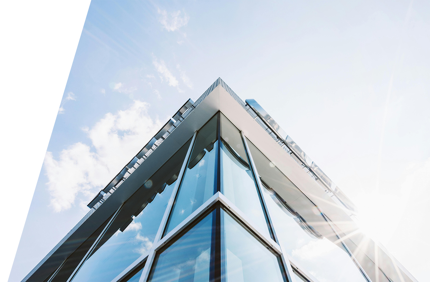 Modern glass office building under blue sky representing corporate offices of a business insurance broker.