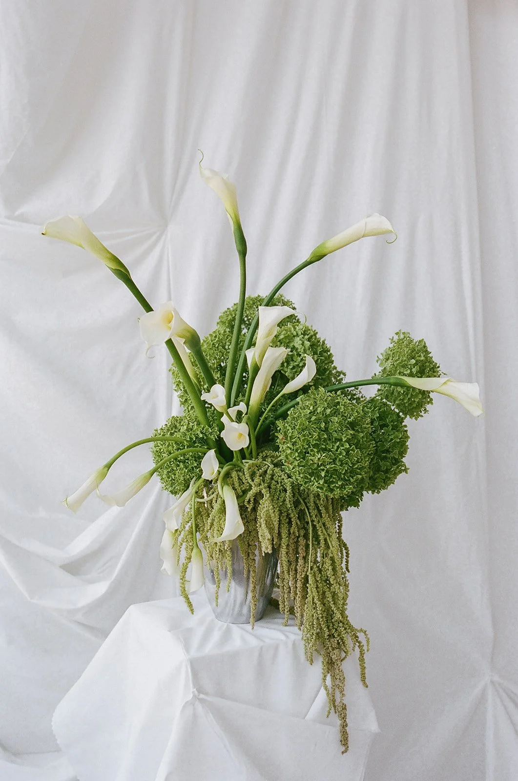 chic editorial baby shower with draped fabric hanging calla lilies minimal architectural centerpieces silver candlesticks the cottage rose full service wedding florist kansas city crossroads modern floral design hydrangea amaranth arrangement