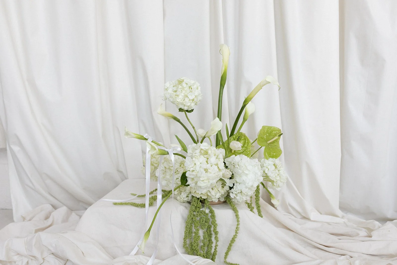 editorial branding shoot flowers maggie routon interior design studio the cottage rose full service wedding florist kansas city crossroads draped fabric ribbon calla lilies anthurium amaranth hydrangea pedestal flower arrangement