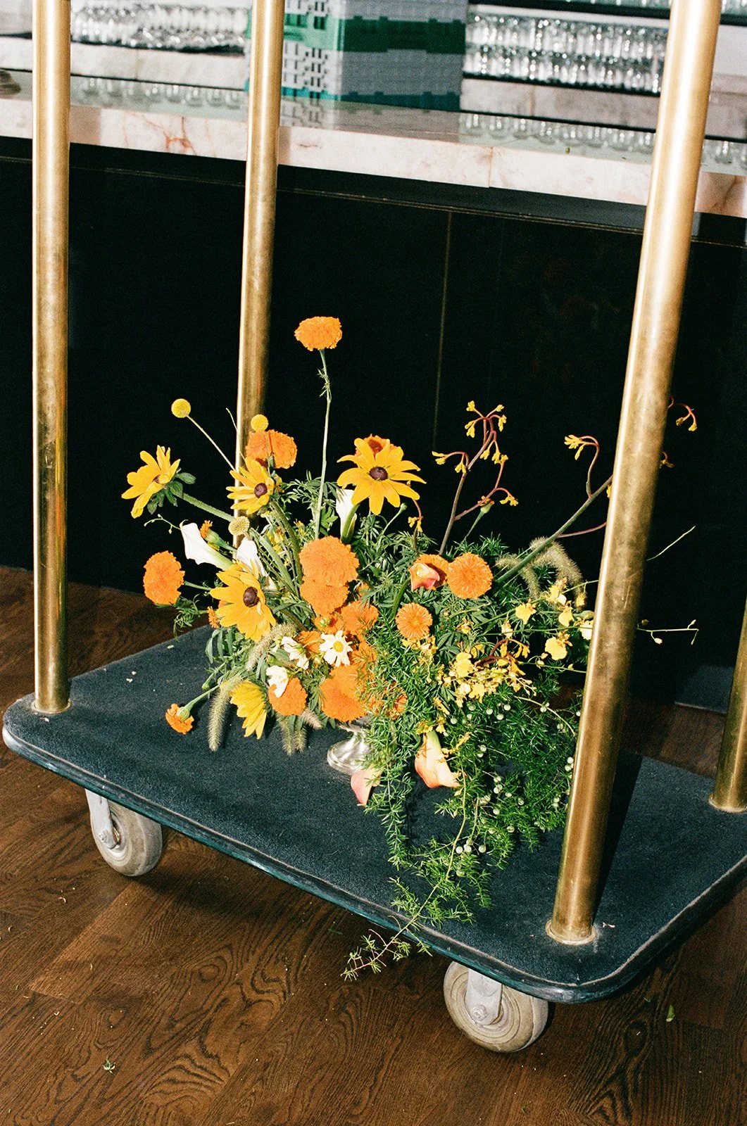 September wedding at Hotel Kansas City mango calla lilies marigolds craspedia the cottage rose full service wedding florist crossroads modern wedding flowers bar floral arrangement orange and yellow