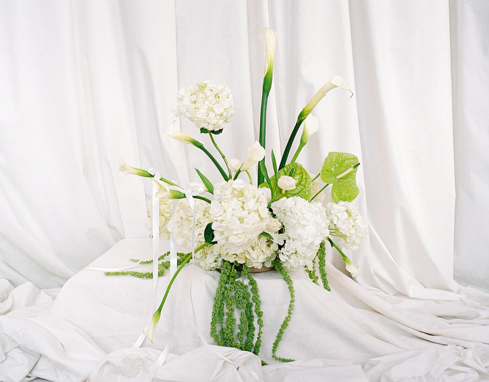 editorial branding shoot flowers maggie routon interior design studio the cottage rose full service wedding florist kansas city crossroads draped fabric ribbon calla lilies anthurium amaranth hydrangea pedestal flower arrangement