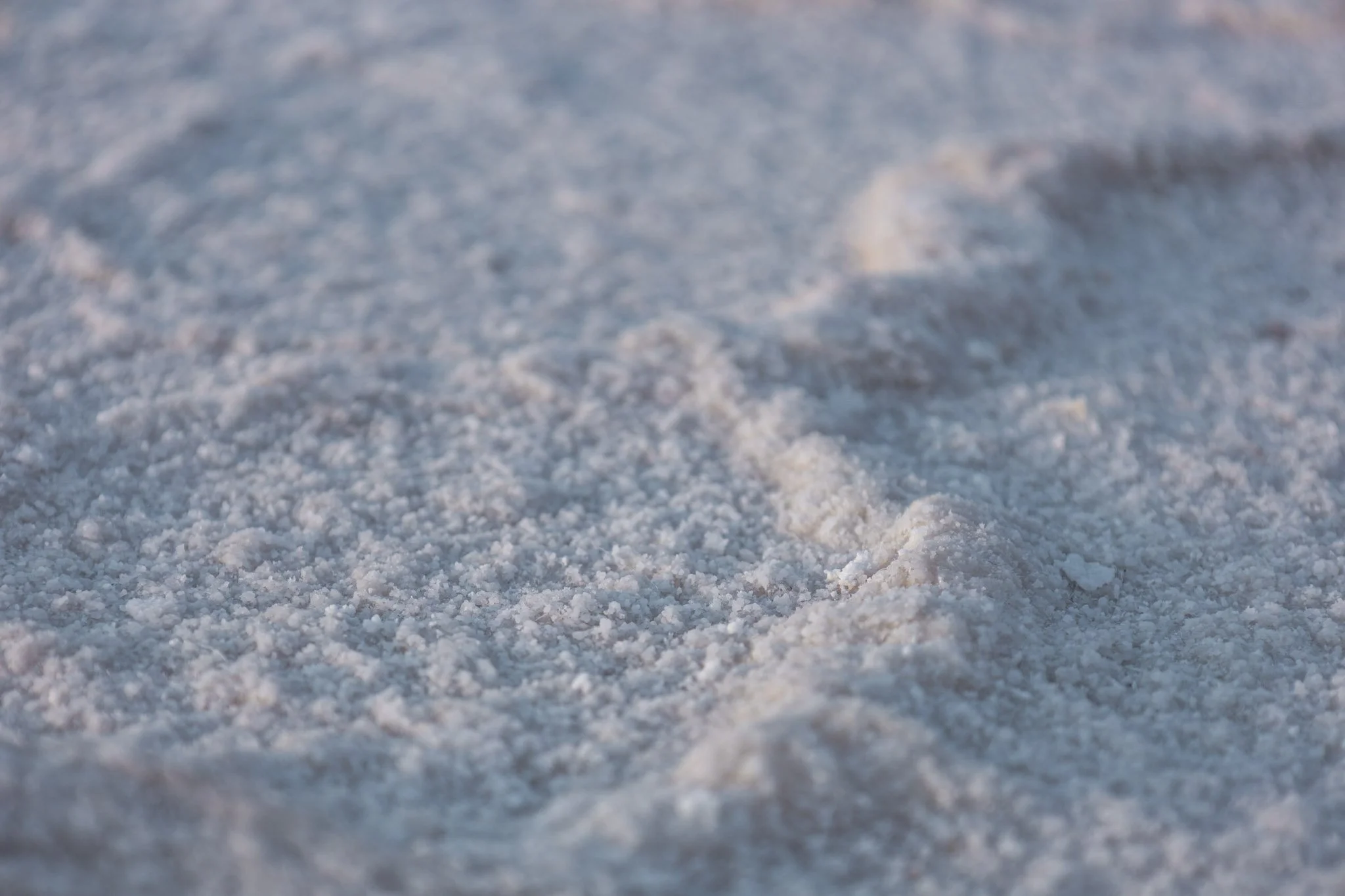Close-up of snow-covered ground with textured surface and small ridges.