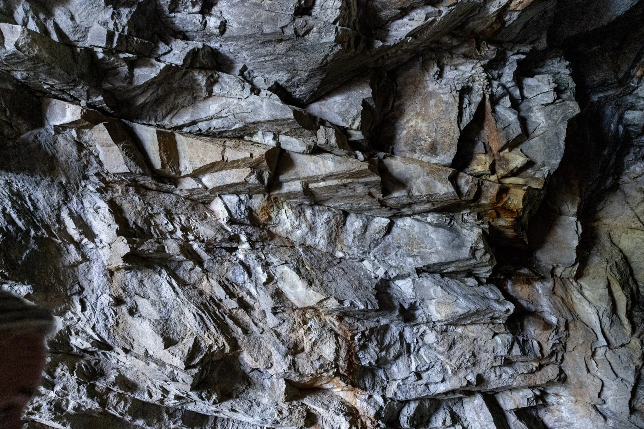 A rocky underground cave ceiling with jagged gray rocks.