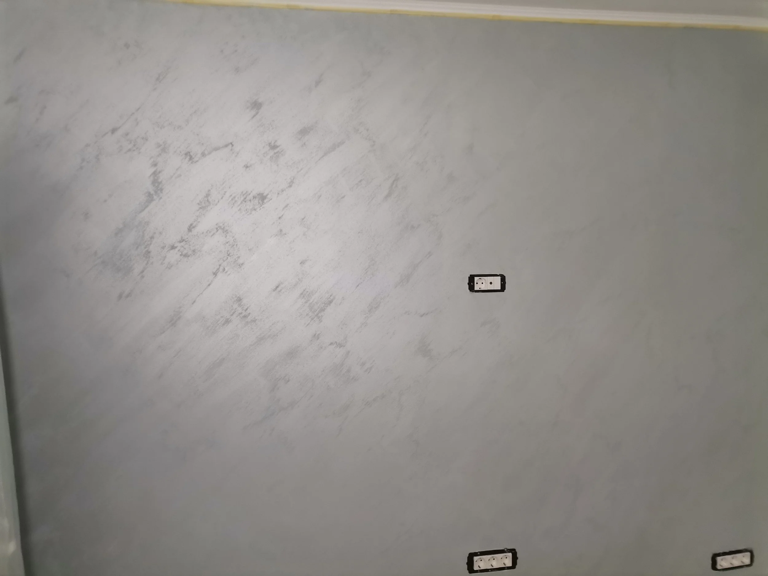 Empty white wall with a power outlet and a switch.