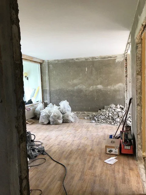 Før renoveringen: stuen med rå betongvegger og riveavfall