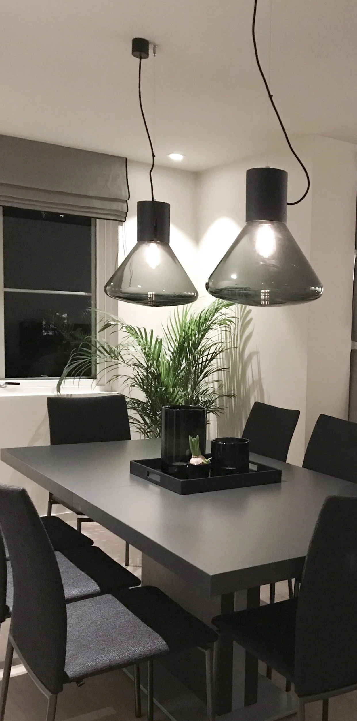 Spisebord med to pendler i røykglass og palme ved vinduet, Tonsenhagen