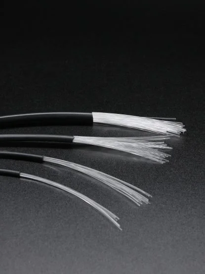 Firewire-kabler med kuttede ender, spredt ut på en svart overflate.