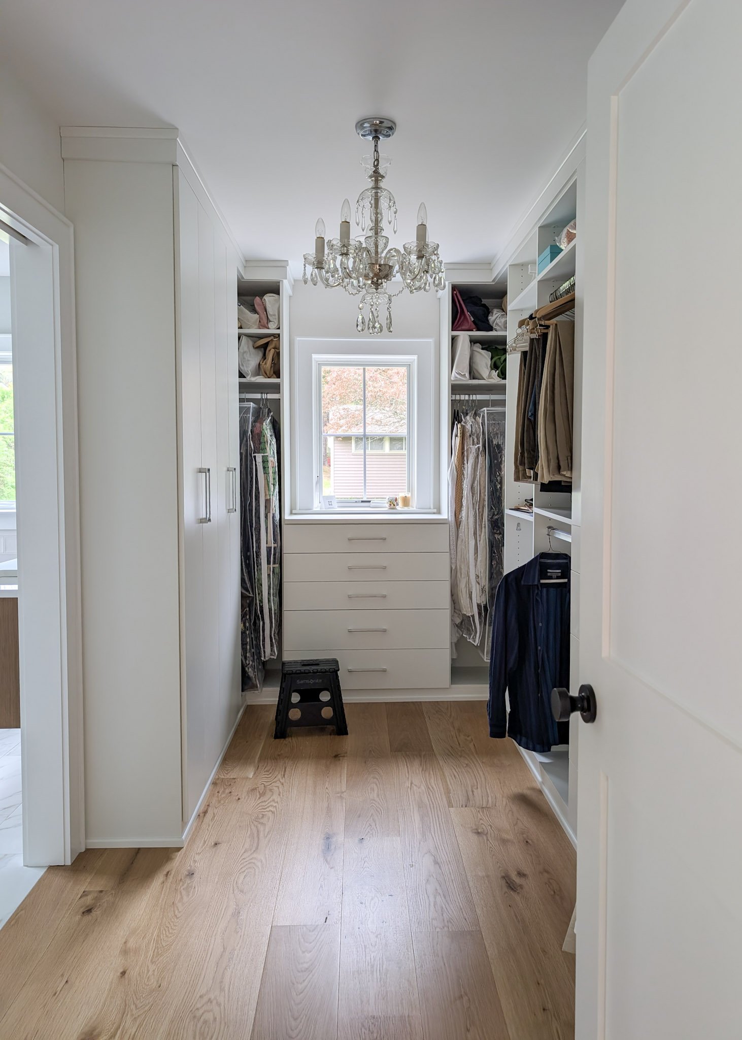 walk in closet with a classic crystal chandelier.
