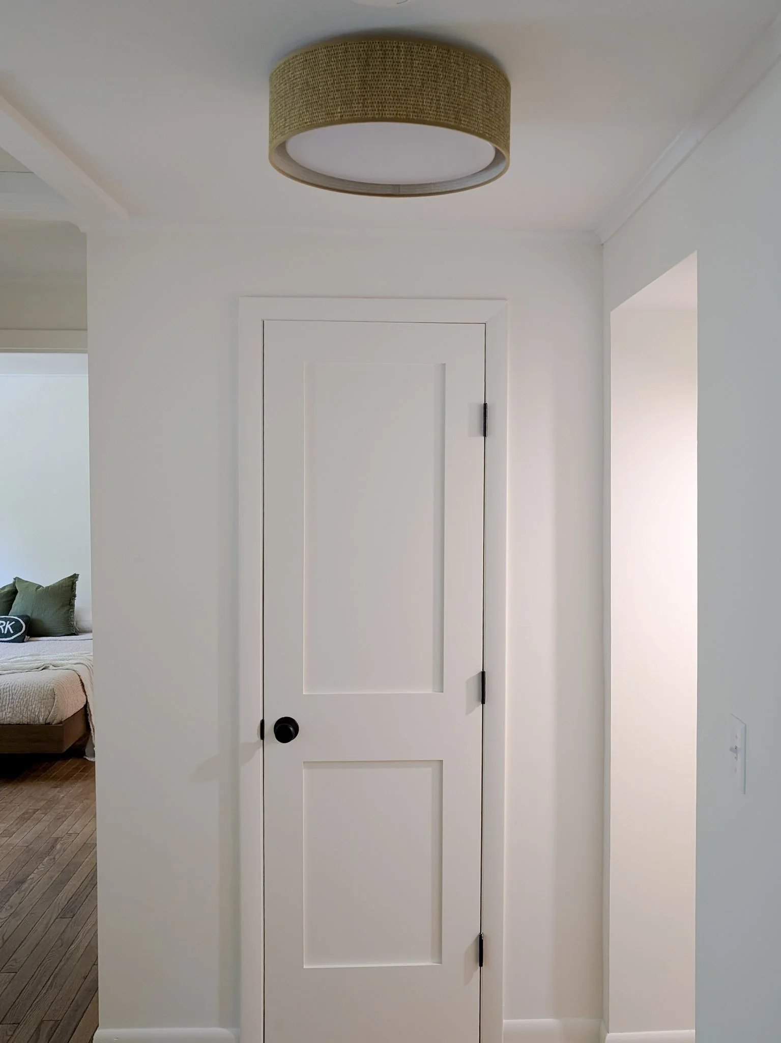 white closed door with woven flush mount light