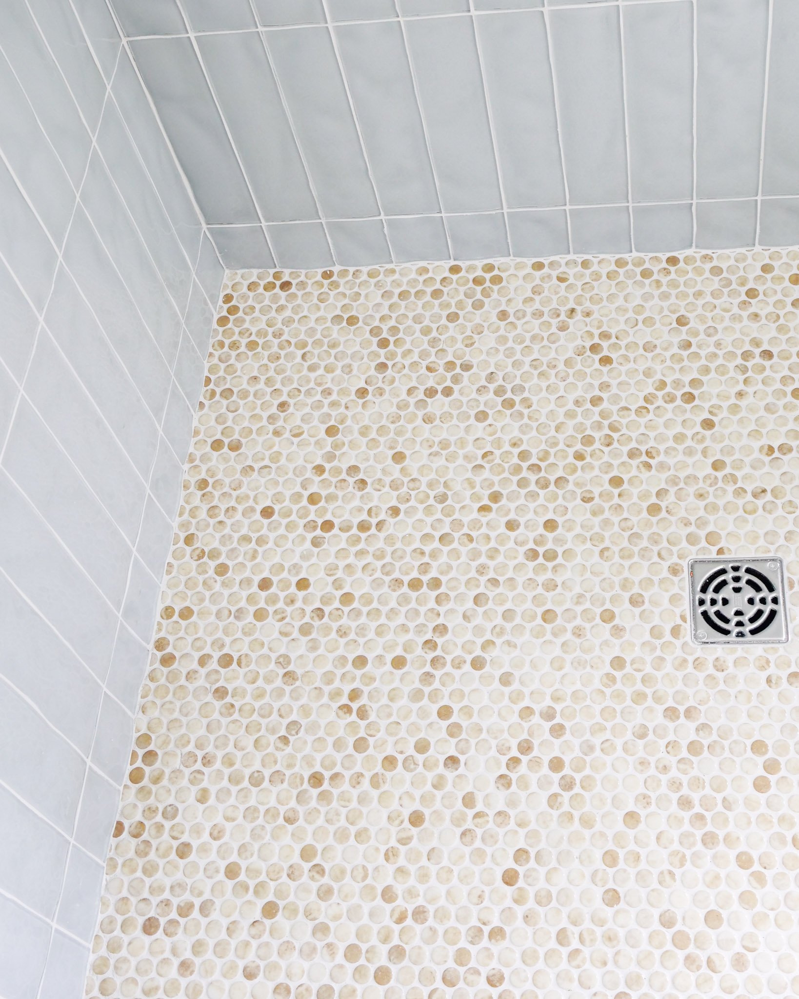 Detail of cool rectangular and warm circle tiles in a shower corner