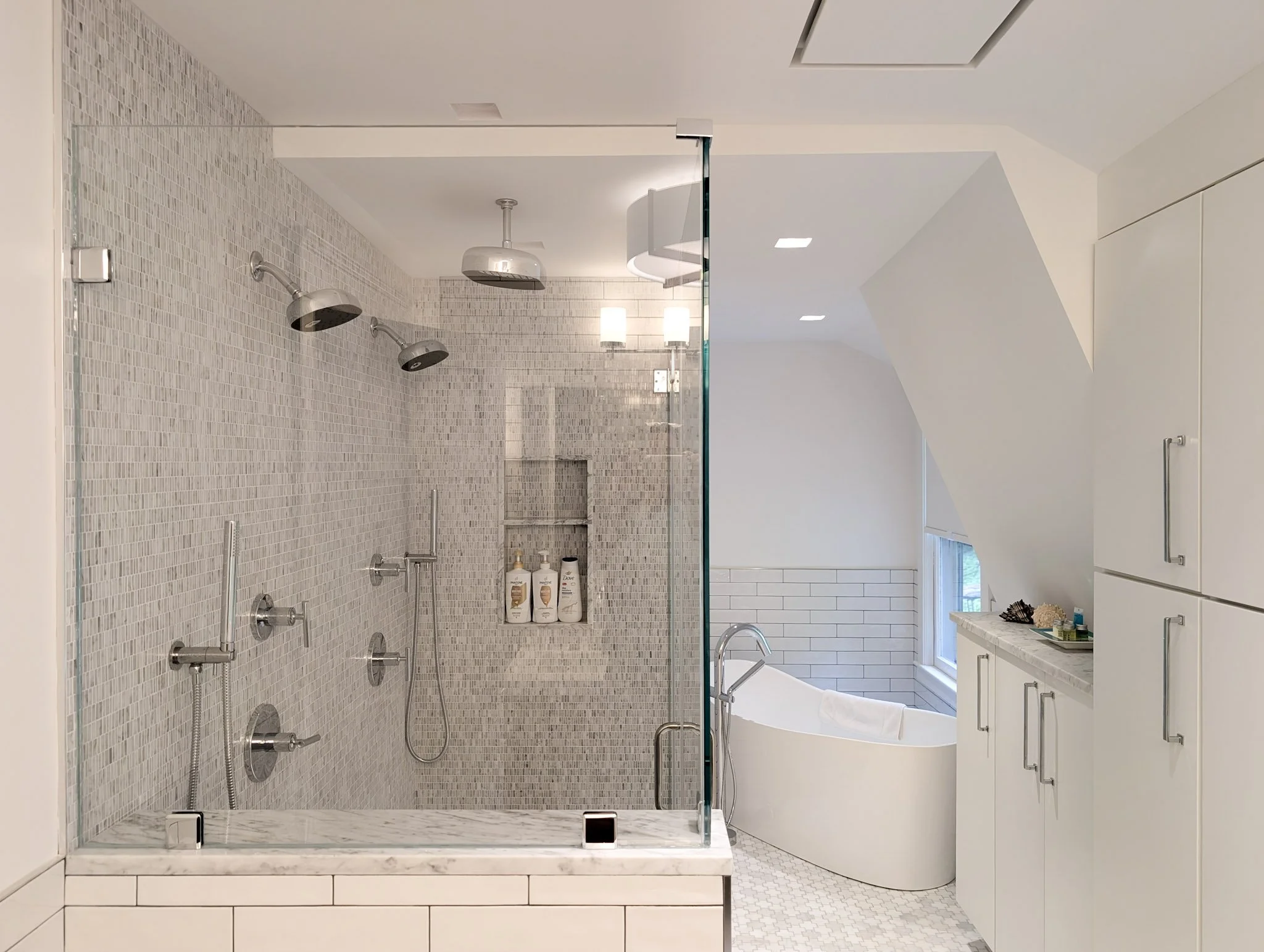 a bathroom with a glass shower and soaking tub