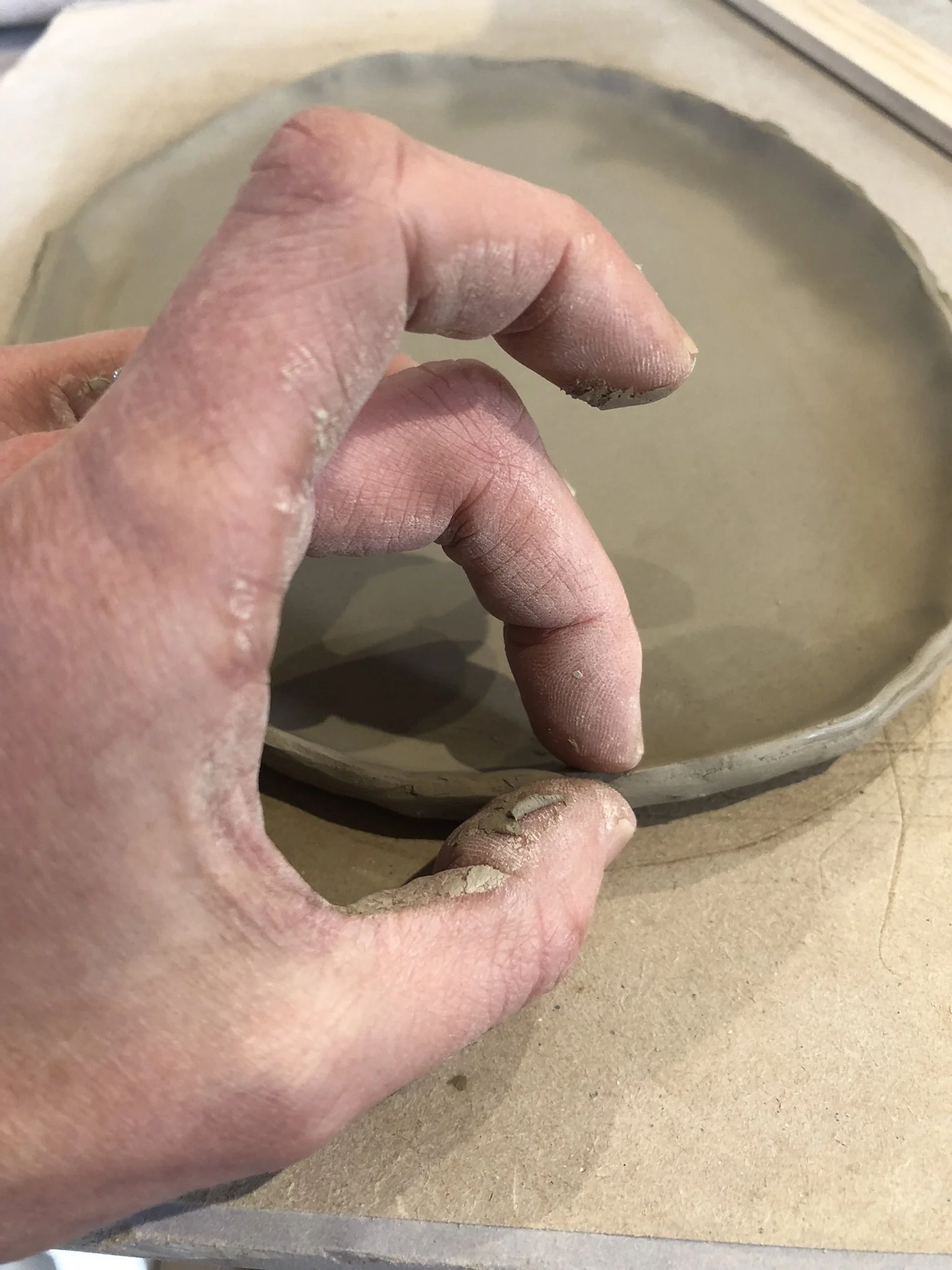 Hands on clay plate.JPEG