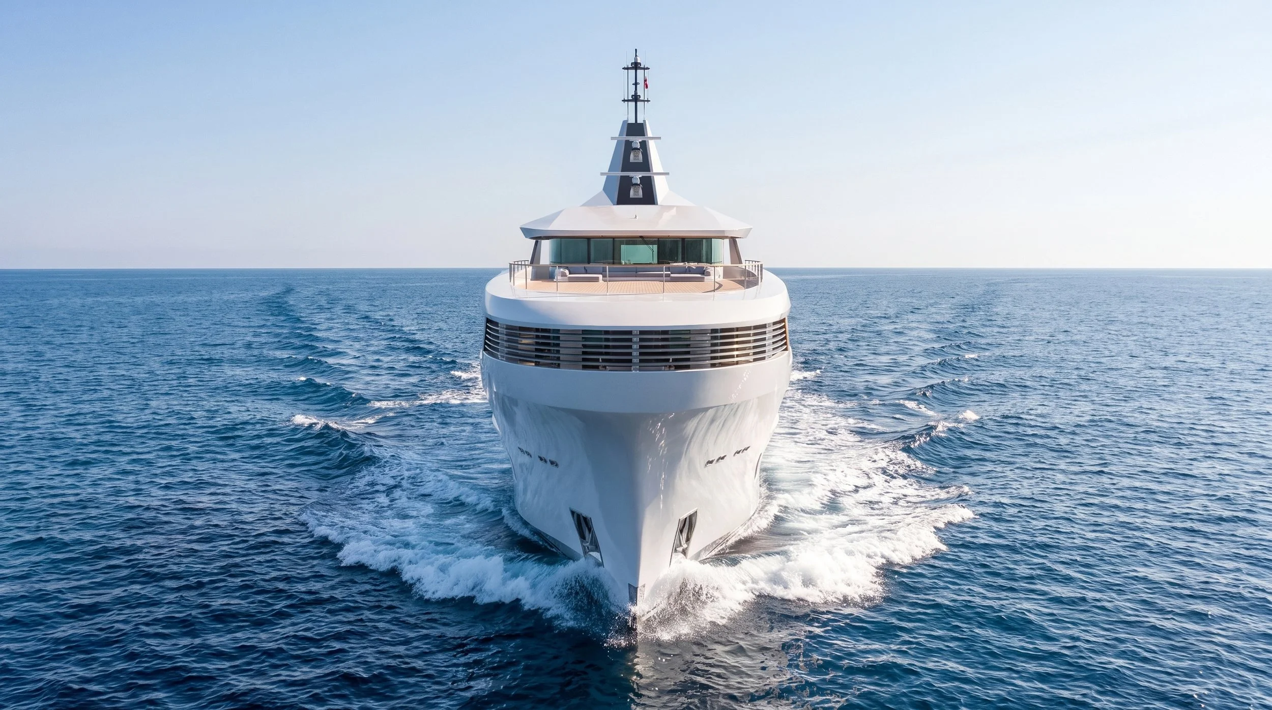 A large white luxury yacht sailing on open water, viewed from the front.