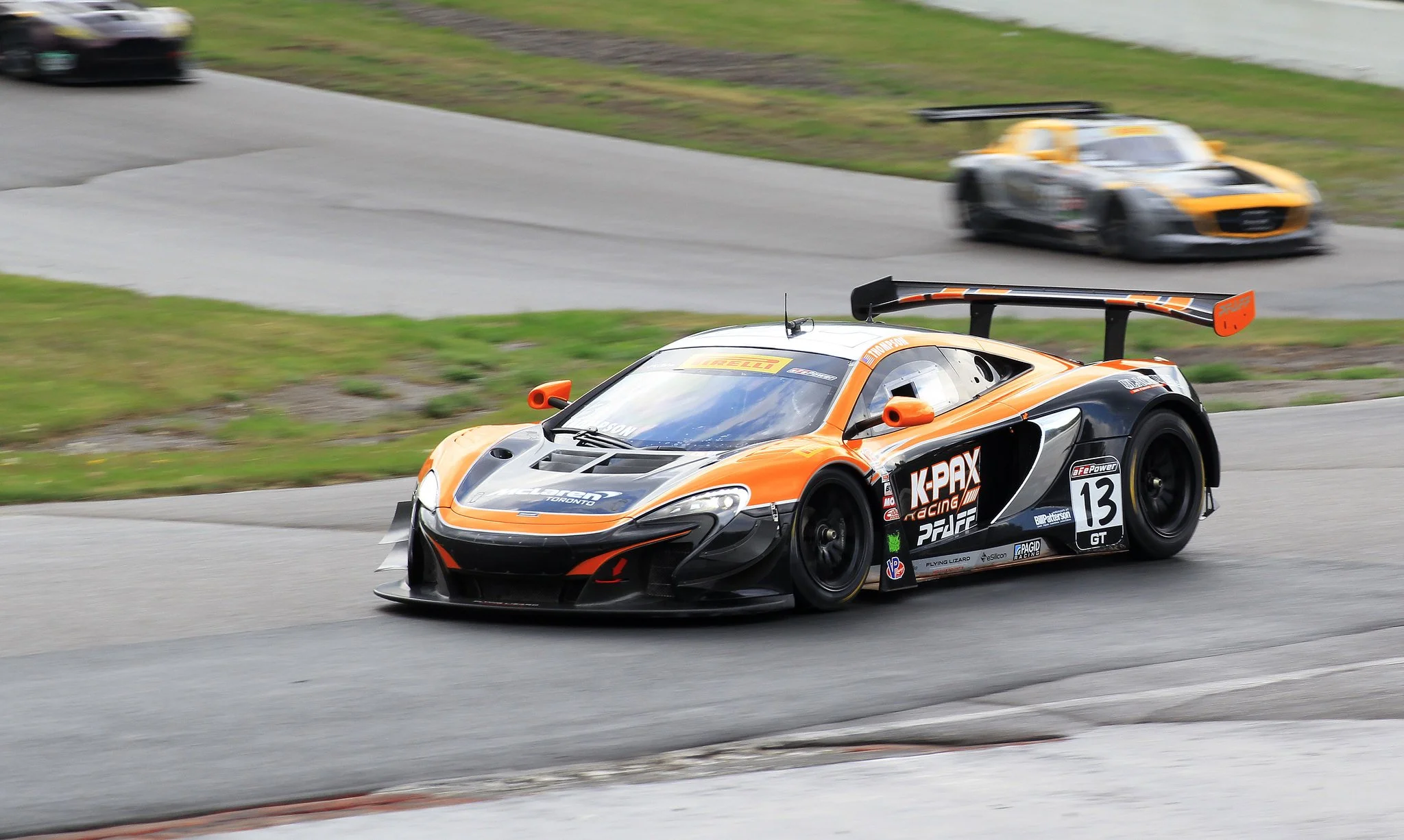 Race car on a racetrack with a second race car in the background