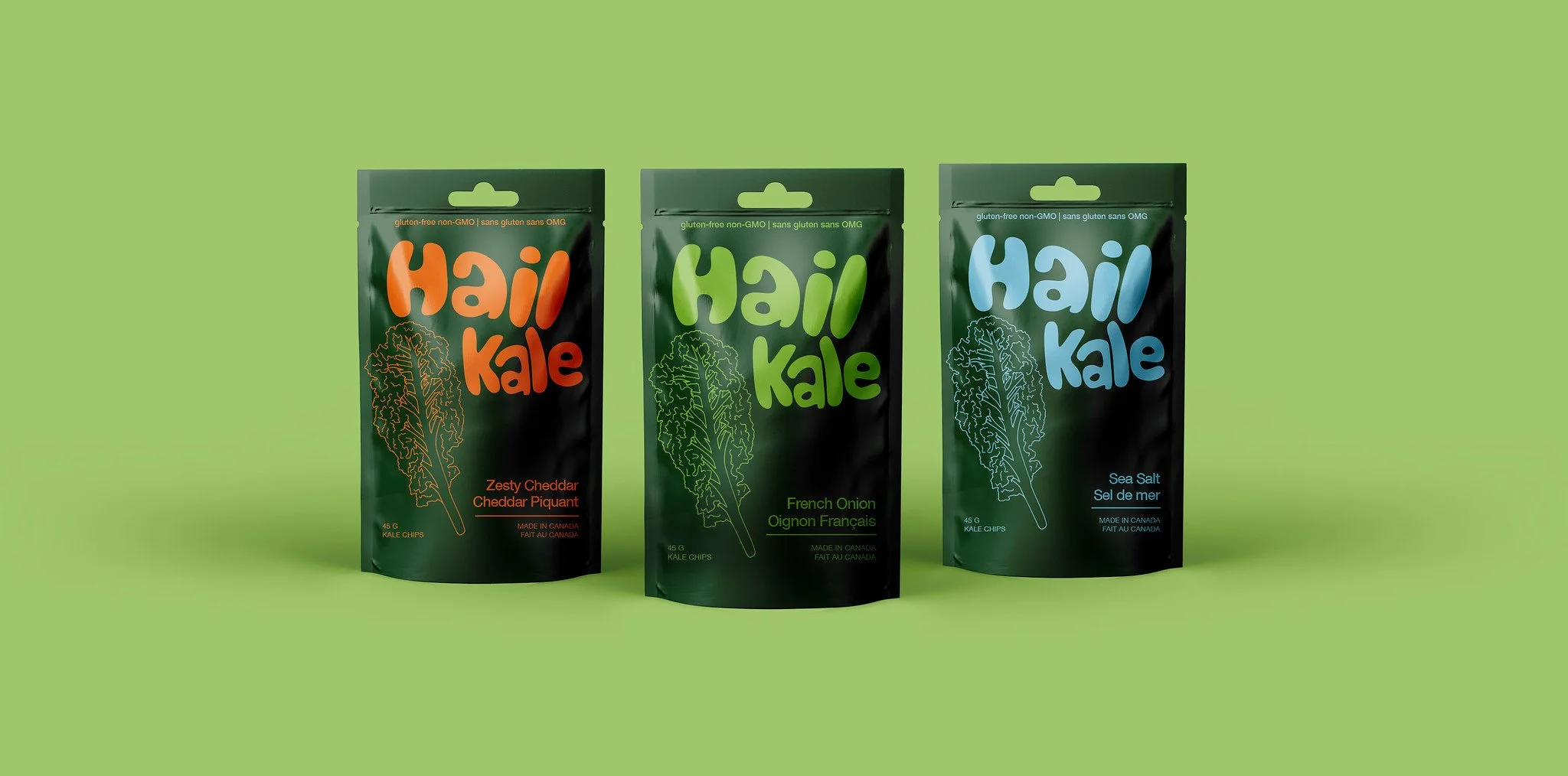 Three packages of Hail Kale snacks in green, black, and dark green pouches with colorful text, labeled Zesty Cheddar, French Onion, and Sea Salt, placed against a light green background.