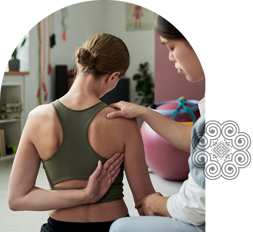 Woman examining a patient's shoulder in a clinic.