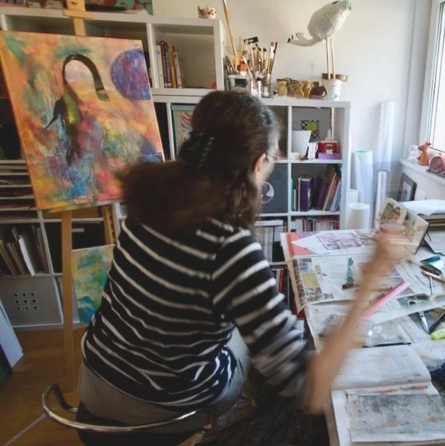 die malende Künstlerin am Atelier-Tisch