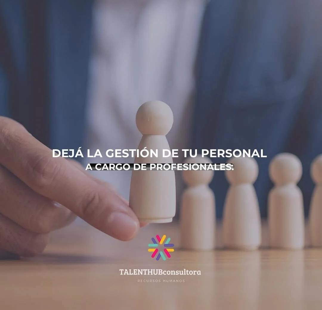 Variante de fichas de madera en forma de personas, con énfasis en una ficha en la que una mano la sostiene, en un ambiente de oficina o reunión.